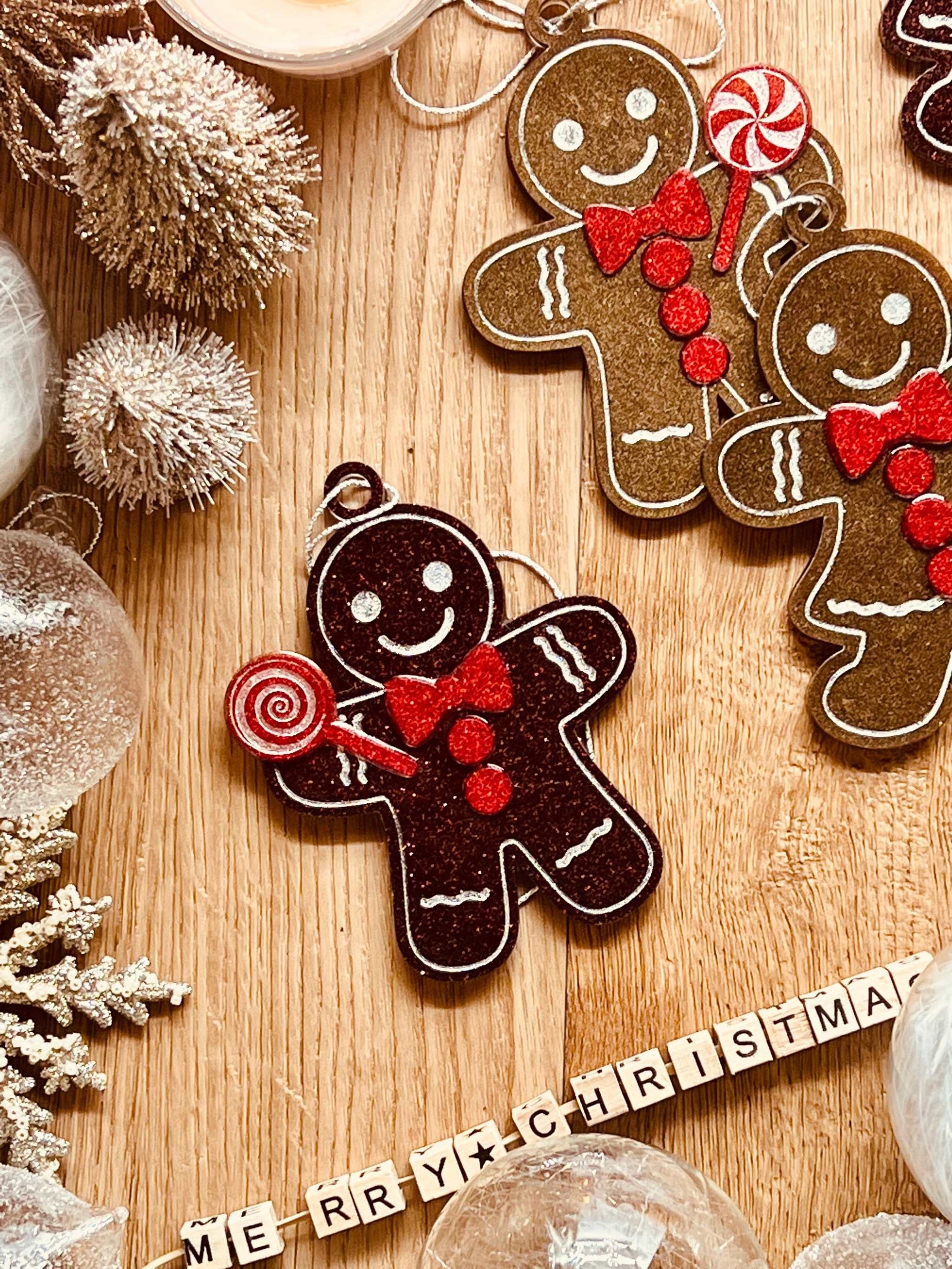 Handmade resin gingerbread man Christmas tree ornaments in brown and red tones.
