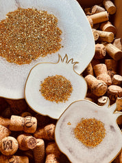 weißes Resin Tablett und 2 Untersetzer mit goldenen Granatapfel-Details auf Weinkorken