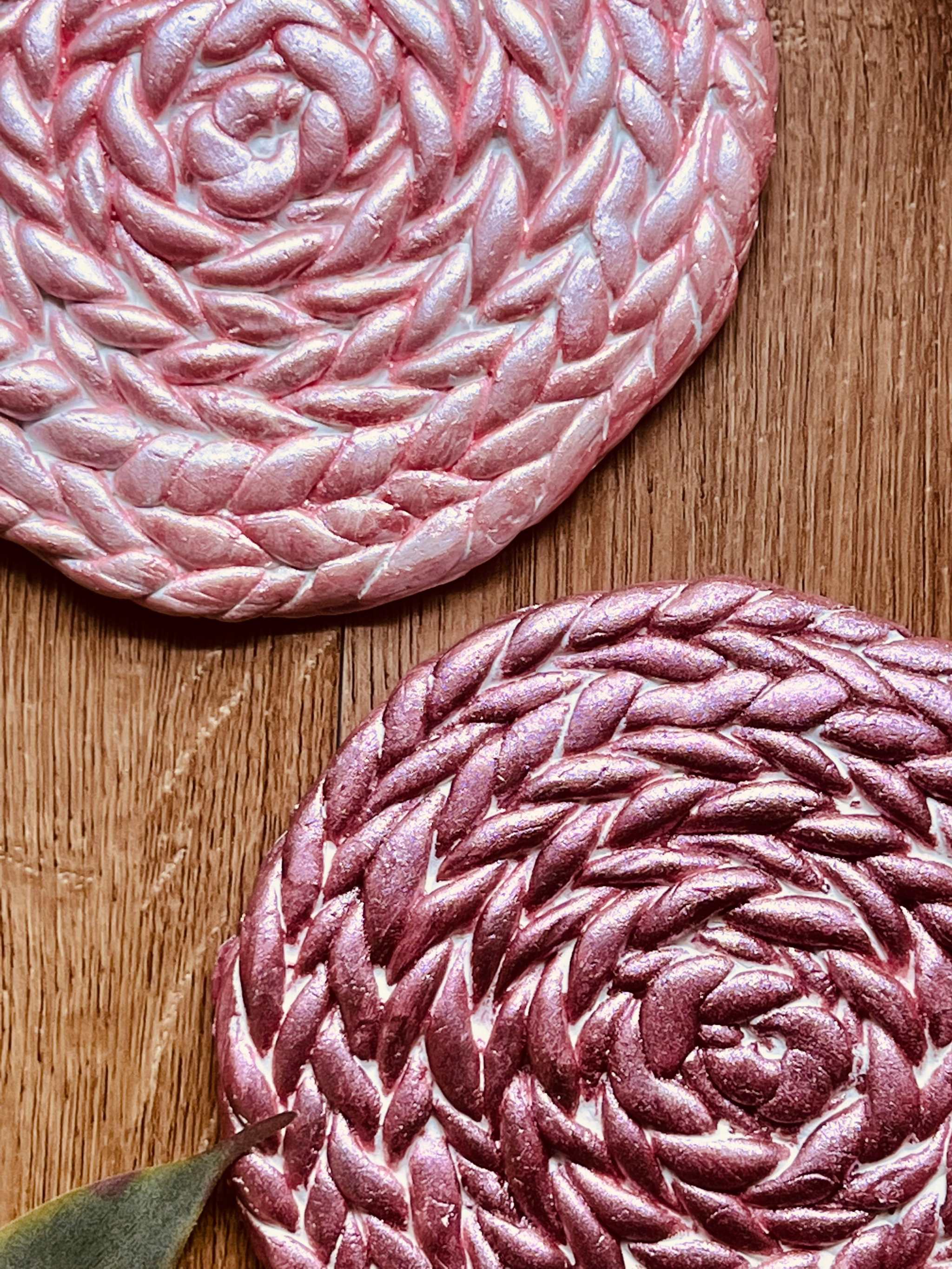 2 Untersetzer aus Clay in rosa und pink handgemacht mit 12 cm Durchmesser auf Holztisch