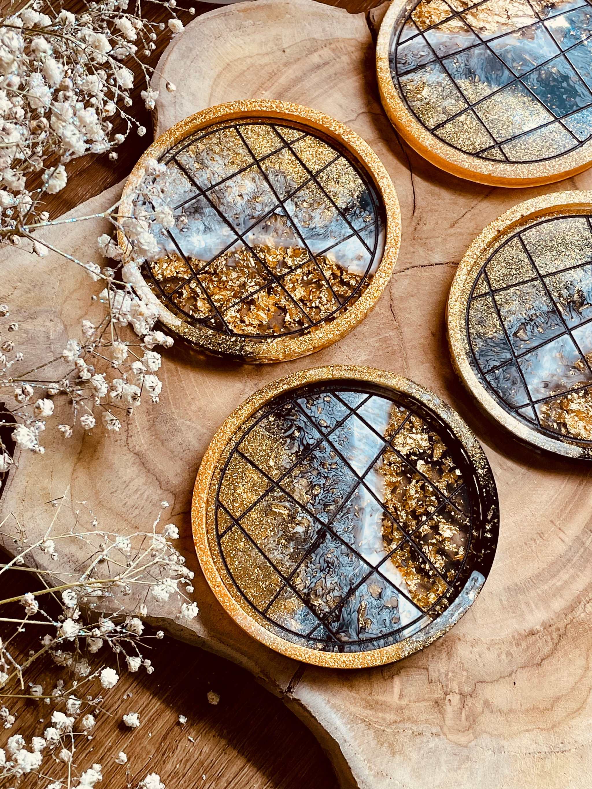 Handgemachte Untersetzer aus Resin in Schwarz Weiß Gold mit LineArt Oberfläche im 4er Set auf Holzplatte