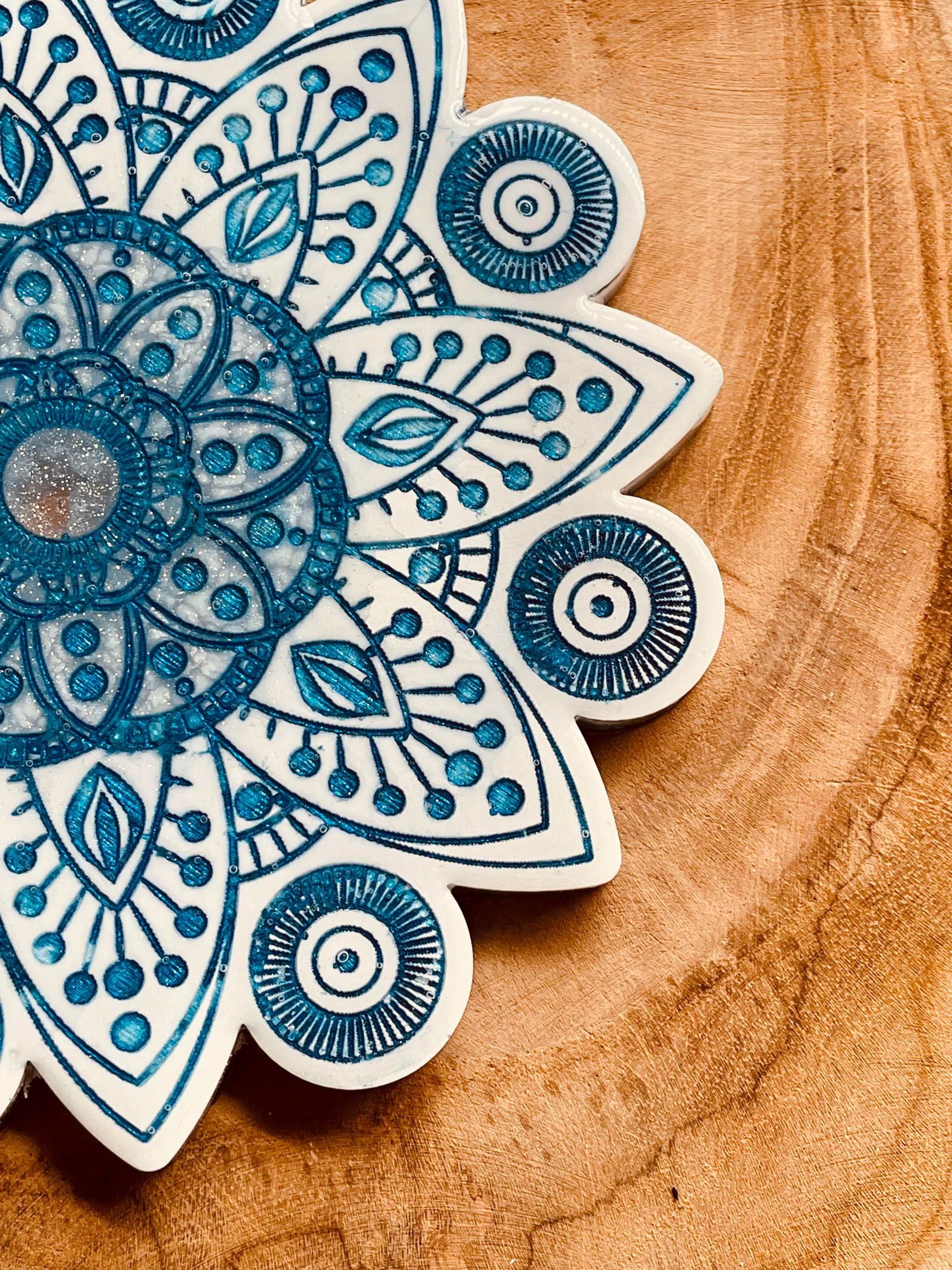 2 Mandala Untersetzer aus Resin in weiss mit blauem Mandala Design auf Holzuntergrund