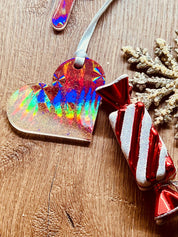 Handgemachte rote und weiße Resin-Weihnachtsbaumanhänger mit holographischer Oberfläche.