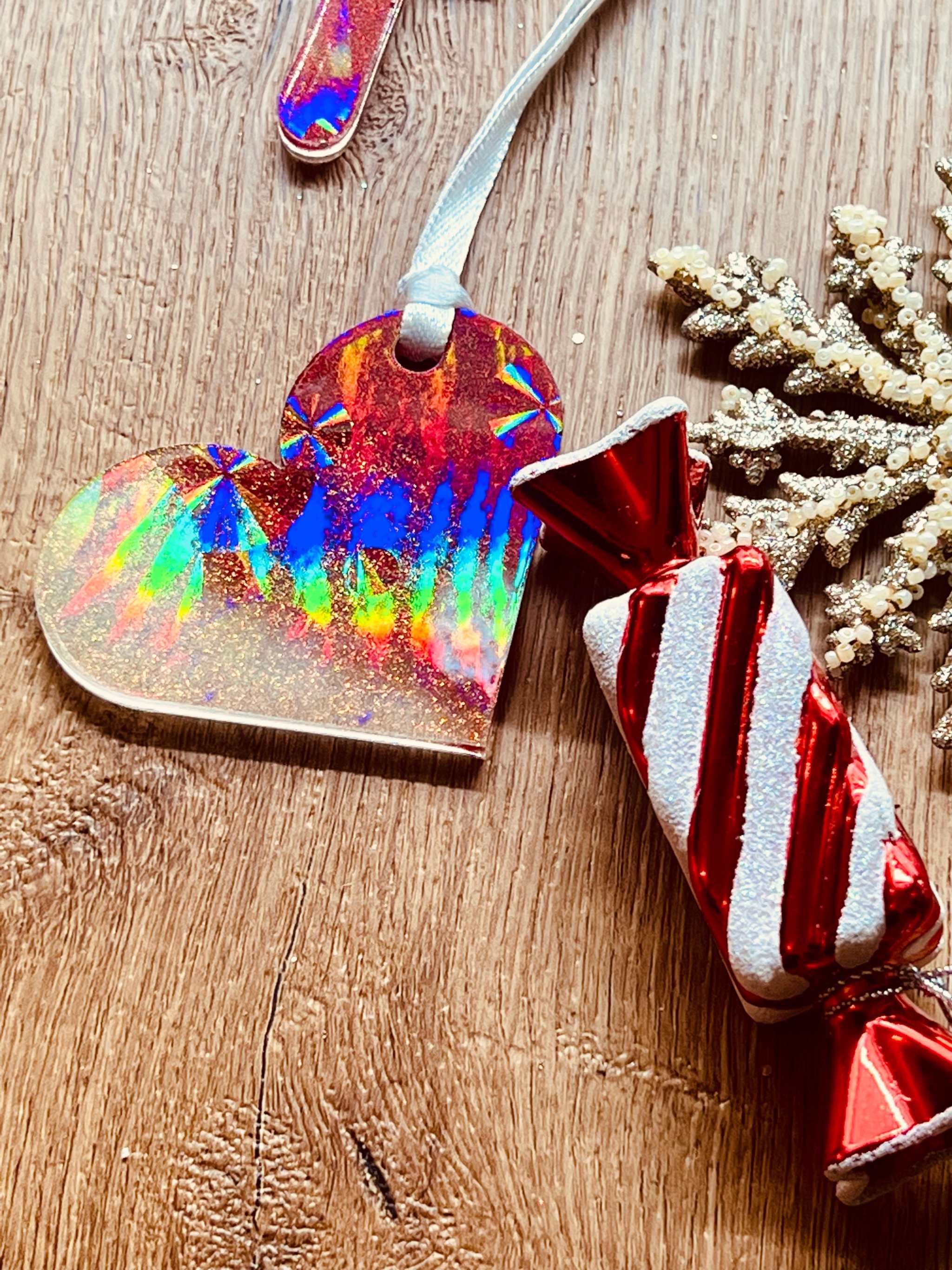 Handgemachte rote und weiße Resin-Weihnachtsbaumanhänger mit holographischer Oberfläche.