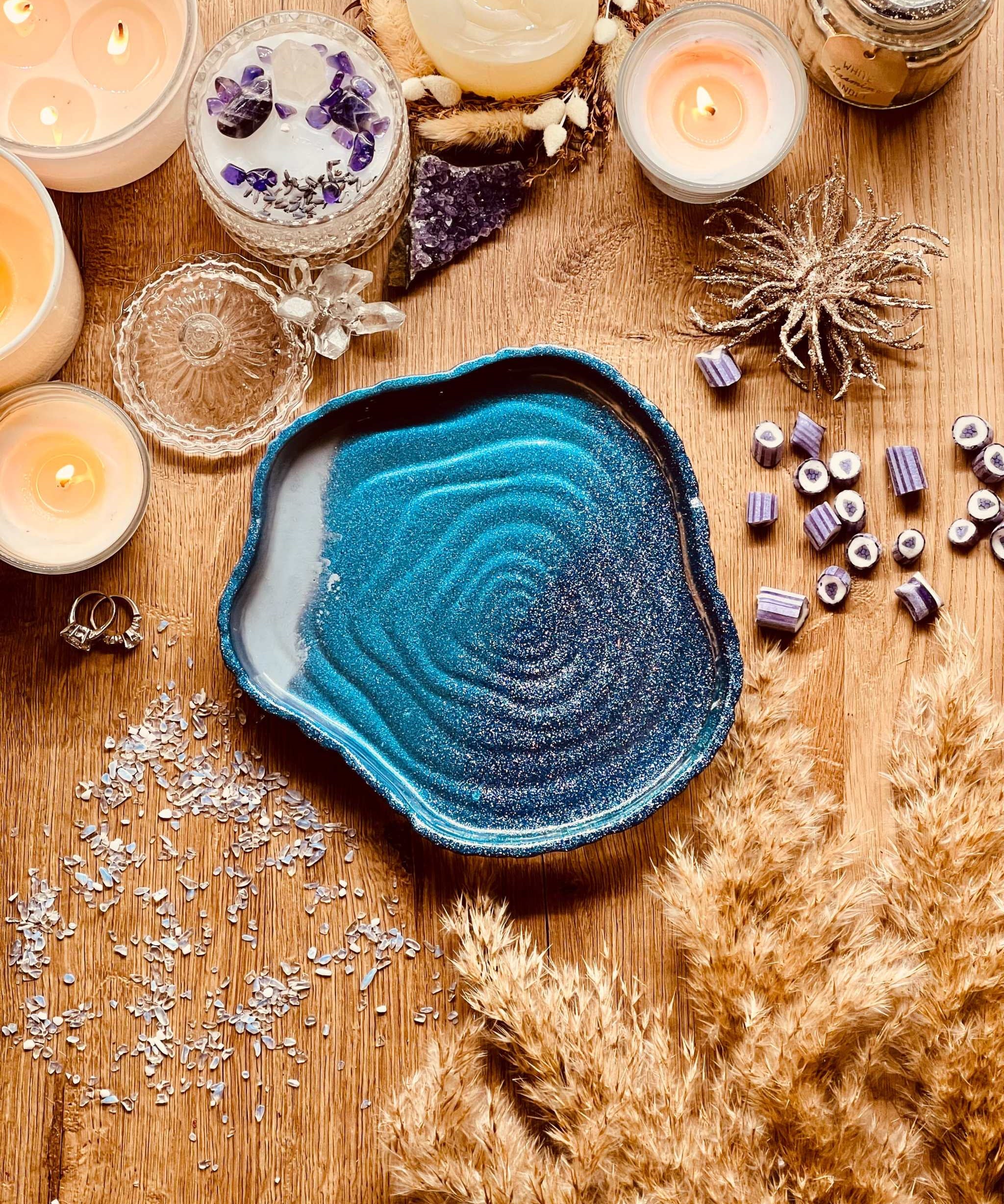 Handgemachte Schale aus Resin in Blautönen auf Holztisch mit Kerzen und Dekoration