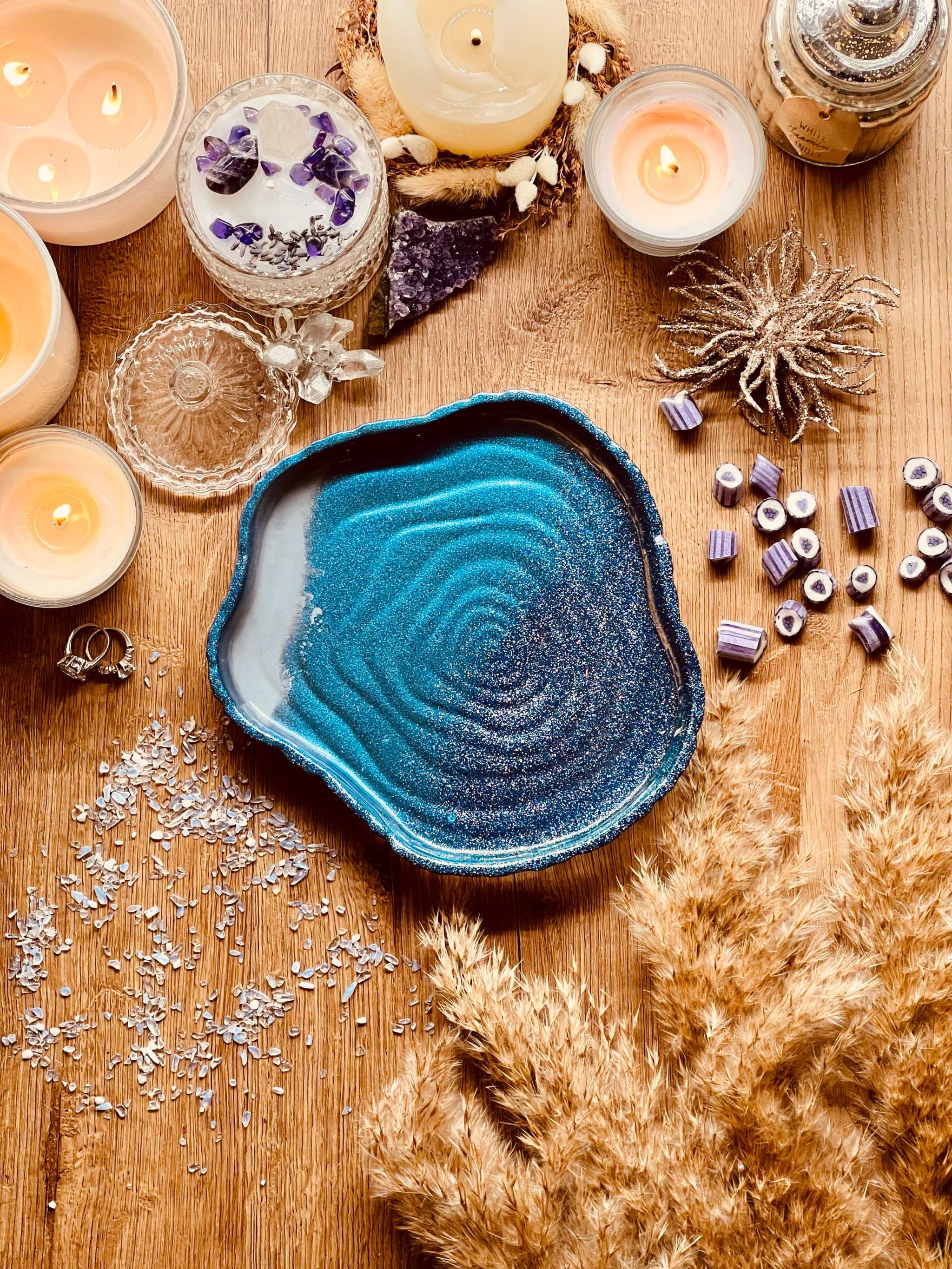 Handgemachte Schale aus Resin in Blautönen auf Holztisch mit Kerzen und Dekoration