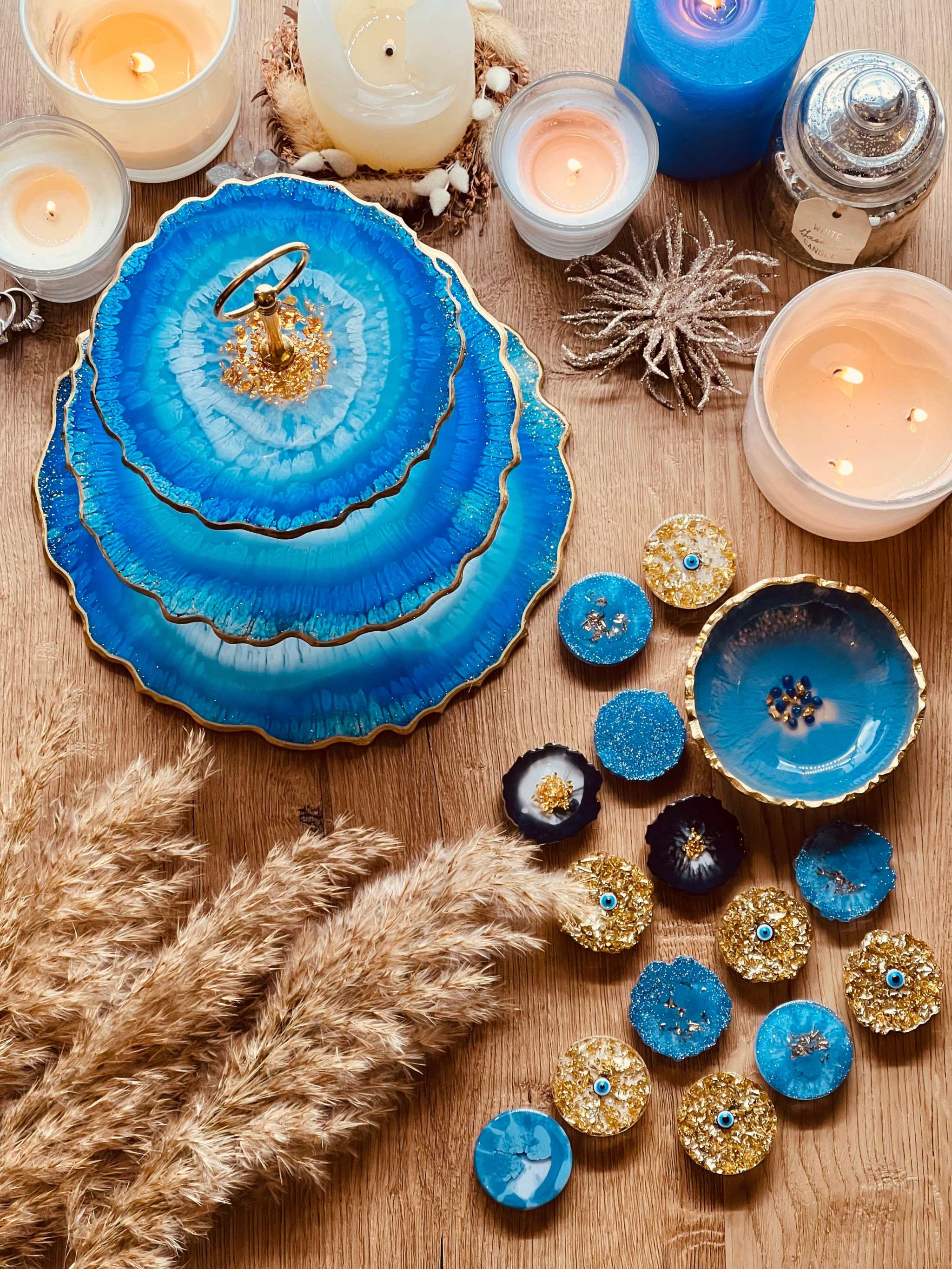 Dreistöckige handgemachte Etagere aus blauem Resin mit geschwungener Form als einzigartige Dekoration auf Holzuntergrund.