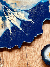 4 Untersetzer aus Resin in Blau mit goldenen Details auf Holztisch