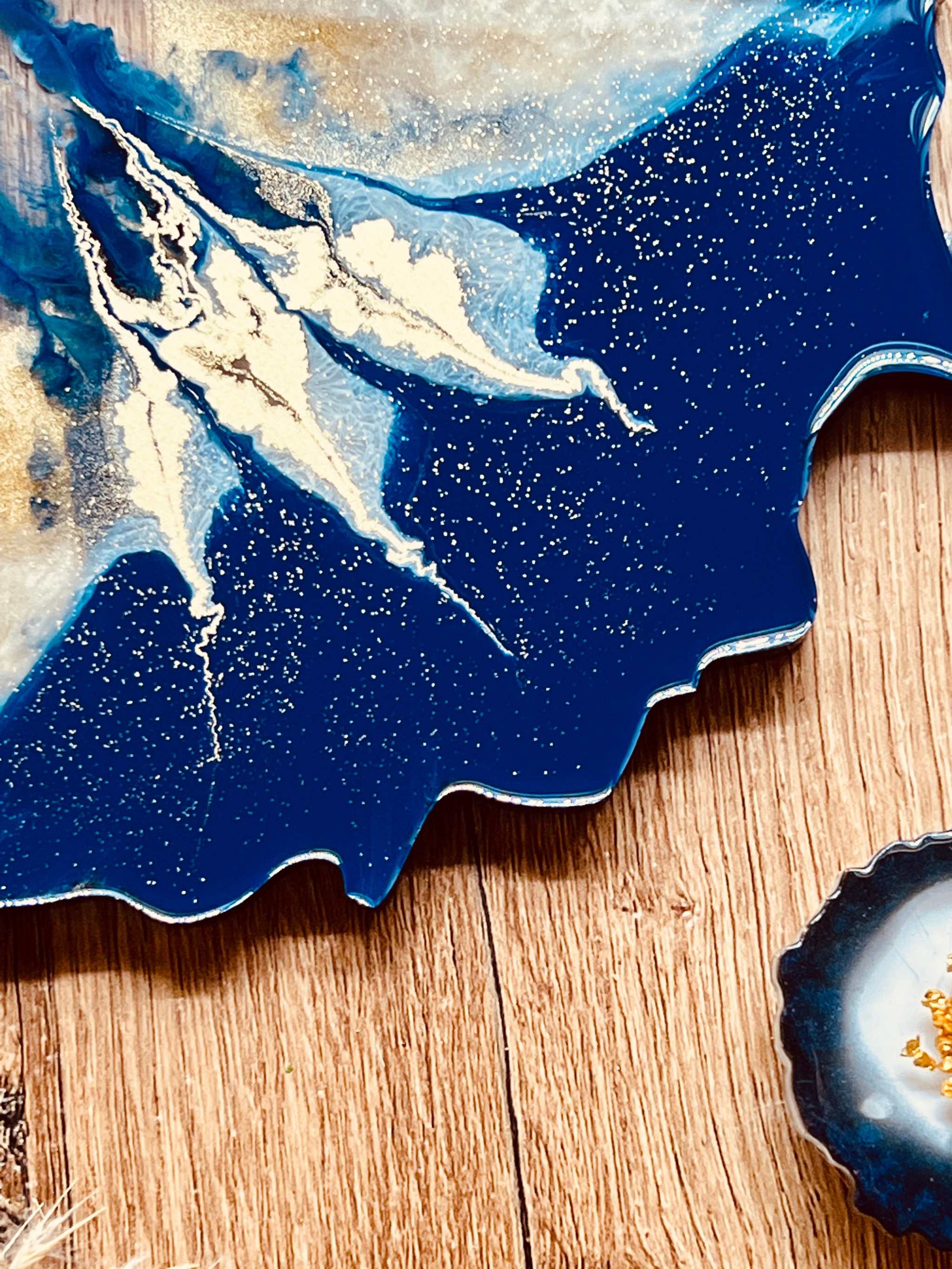 4 Untersetzer aus Resin in Blau mit goldenen Details auf Holztisch