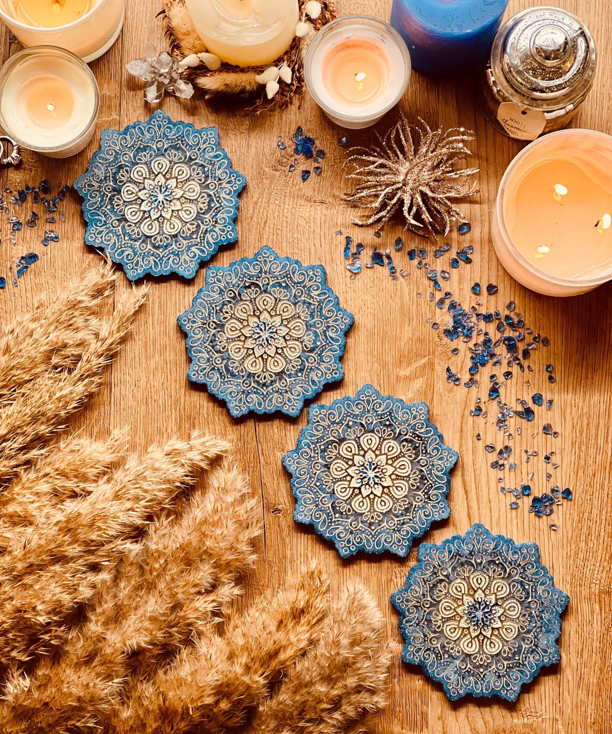 4 Mandala Untersetzer aus Resin in Blau mit goldenen Details auf Holztisch mit Kerzen und Dekoration