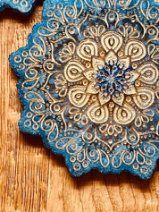 4 Mandala Untersetzer aus blauem Resin mit goldenen Details und filigranem Mandala Design auf Holztisch