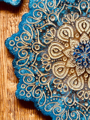 4 Mandala Untersetzer aus blauem Resin mit goldenen Details auf Holztisch