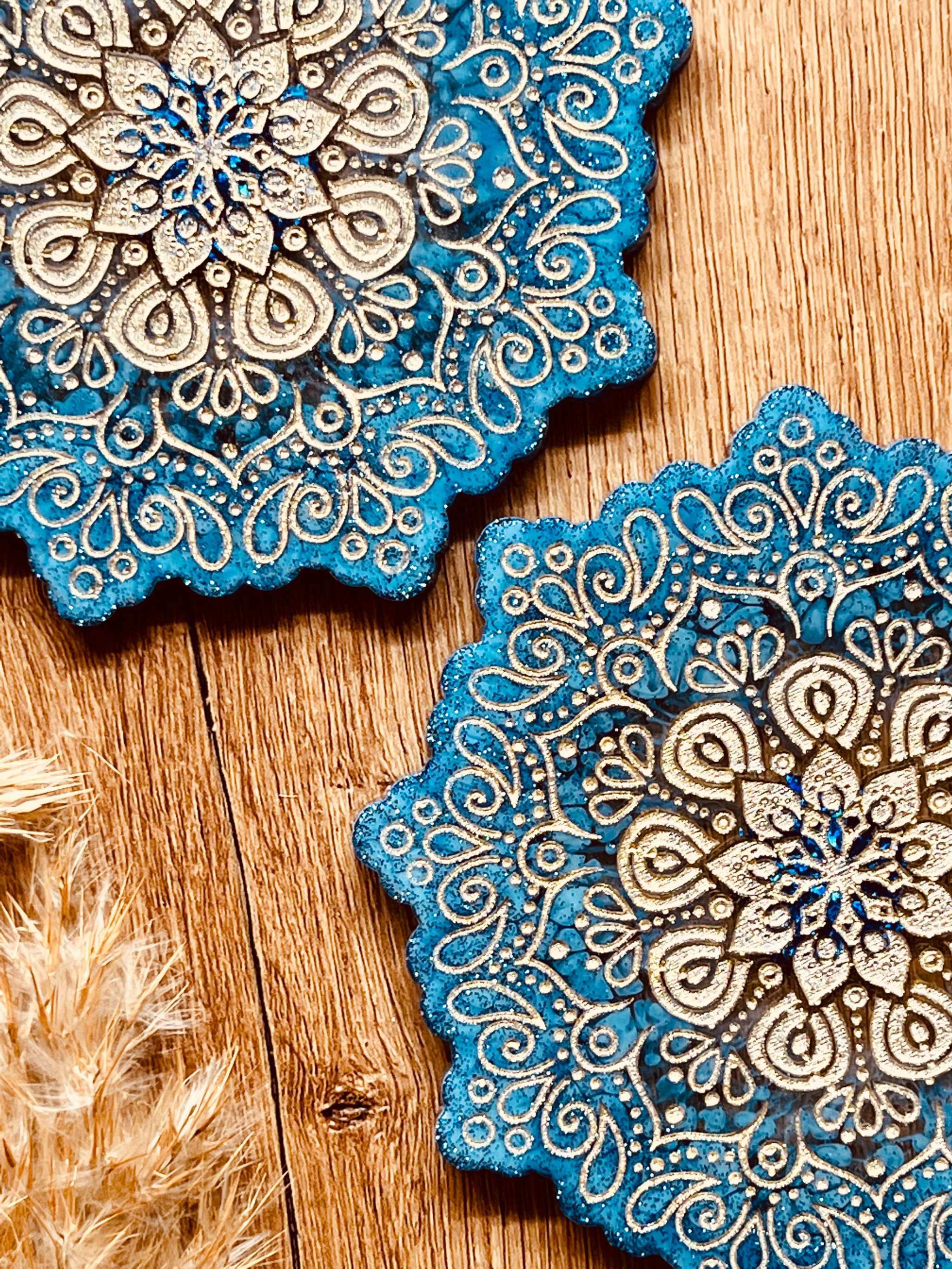 4 Mandala Untersetzer aus blauem Resin mit goldenen Details auf Holztisch