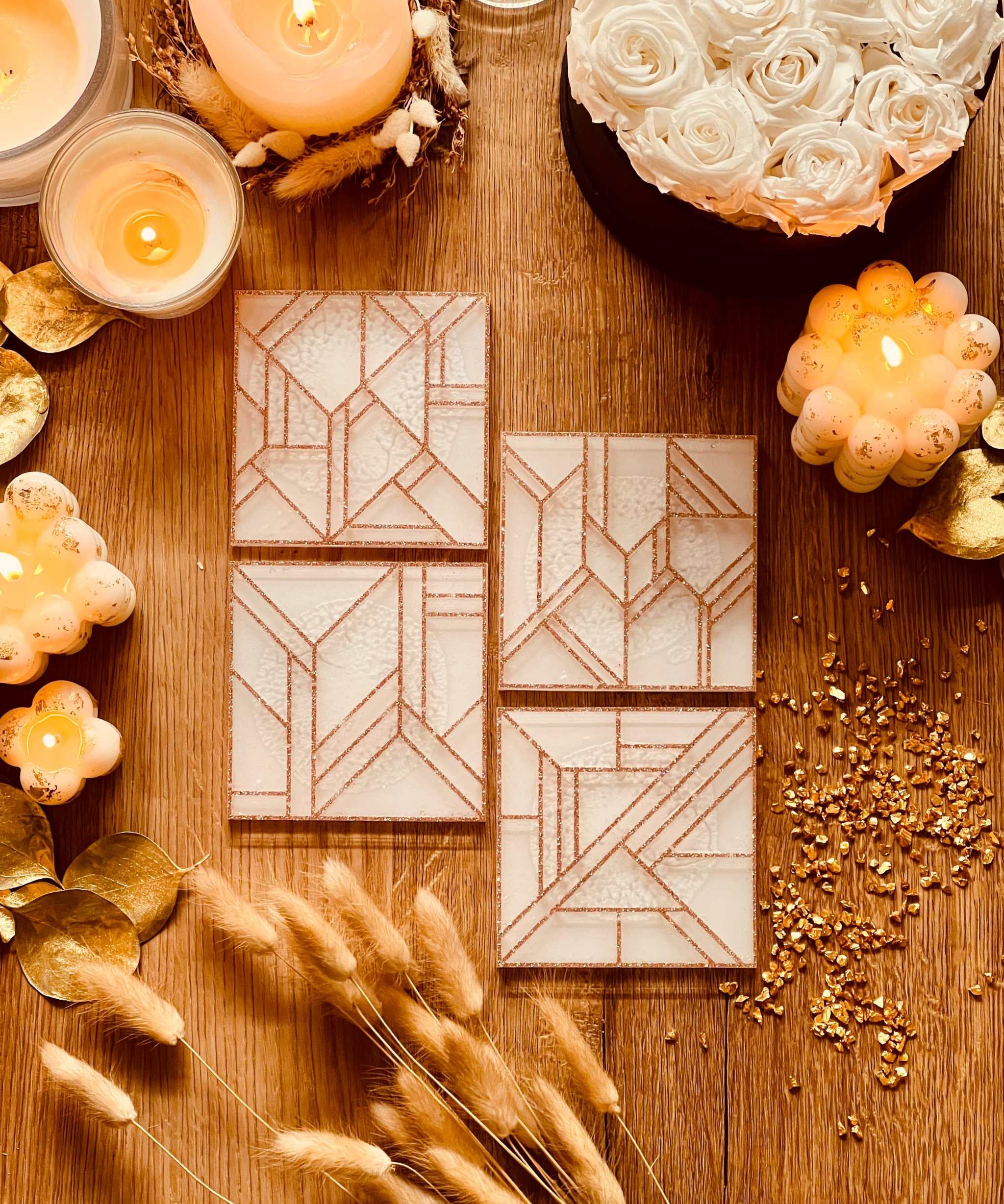 4 moderne Untersetzer aus weißem Resin mit goldenem 3D-Design auf Holztisch dekorativ arrangiert