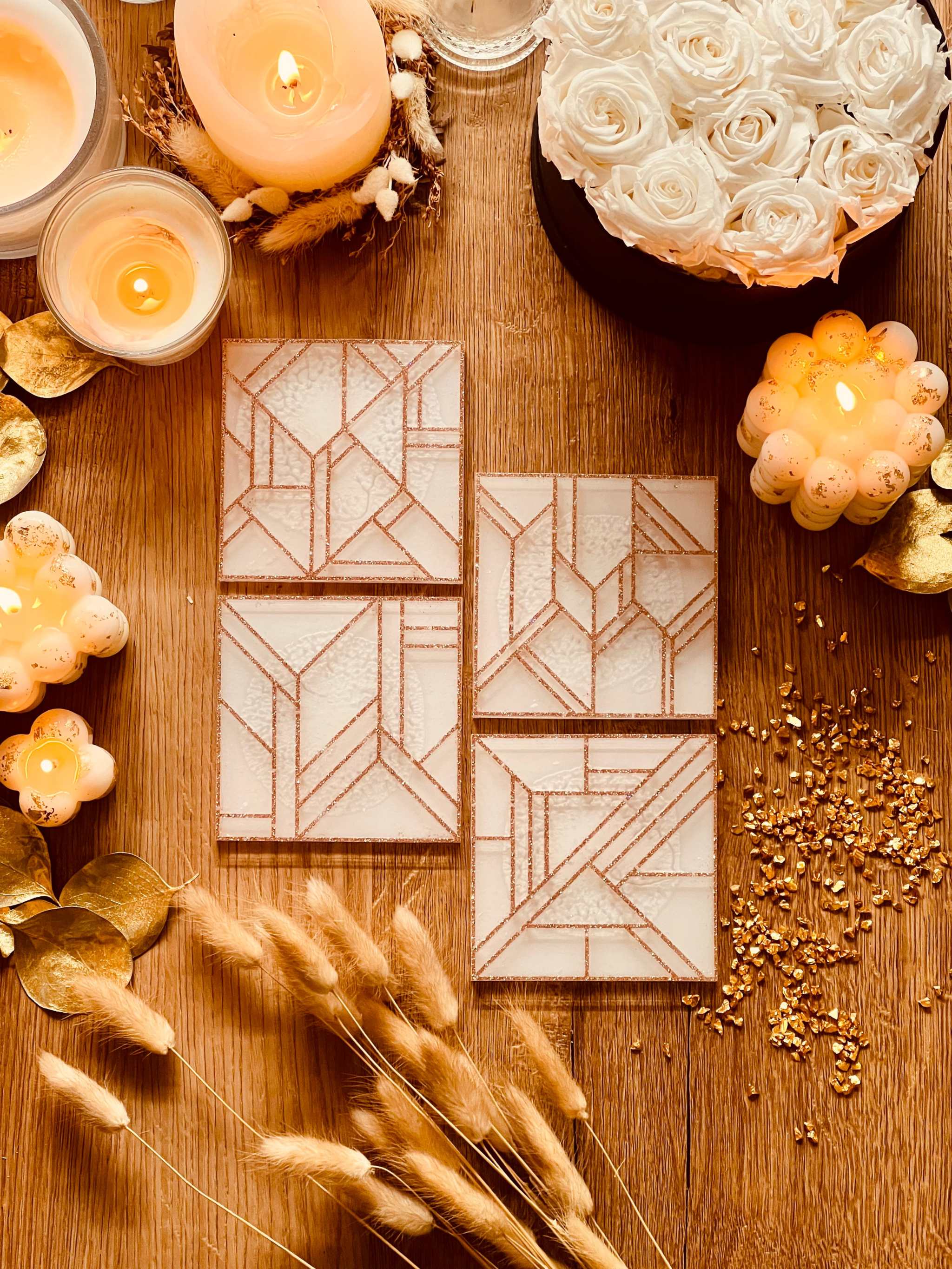4 moderne Untersetzer aus weißem Resin mit goldenem 3D-Design auf Holztisch dekorativ arrangiert