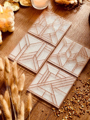moderne weiße Resin Untersetzer mit goldenem 3D Design im 4er Set auf Holztisch