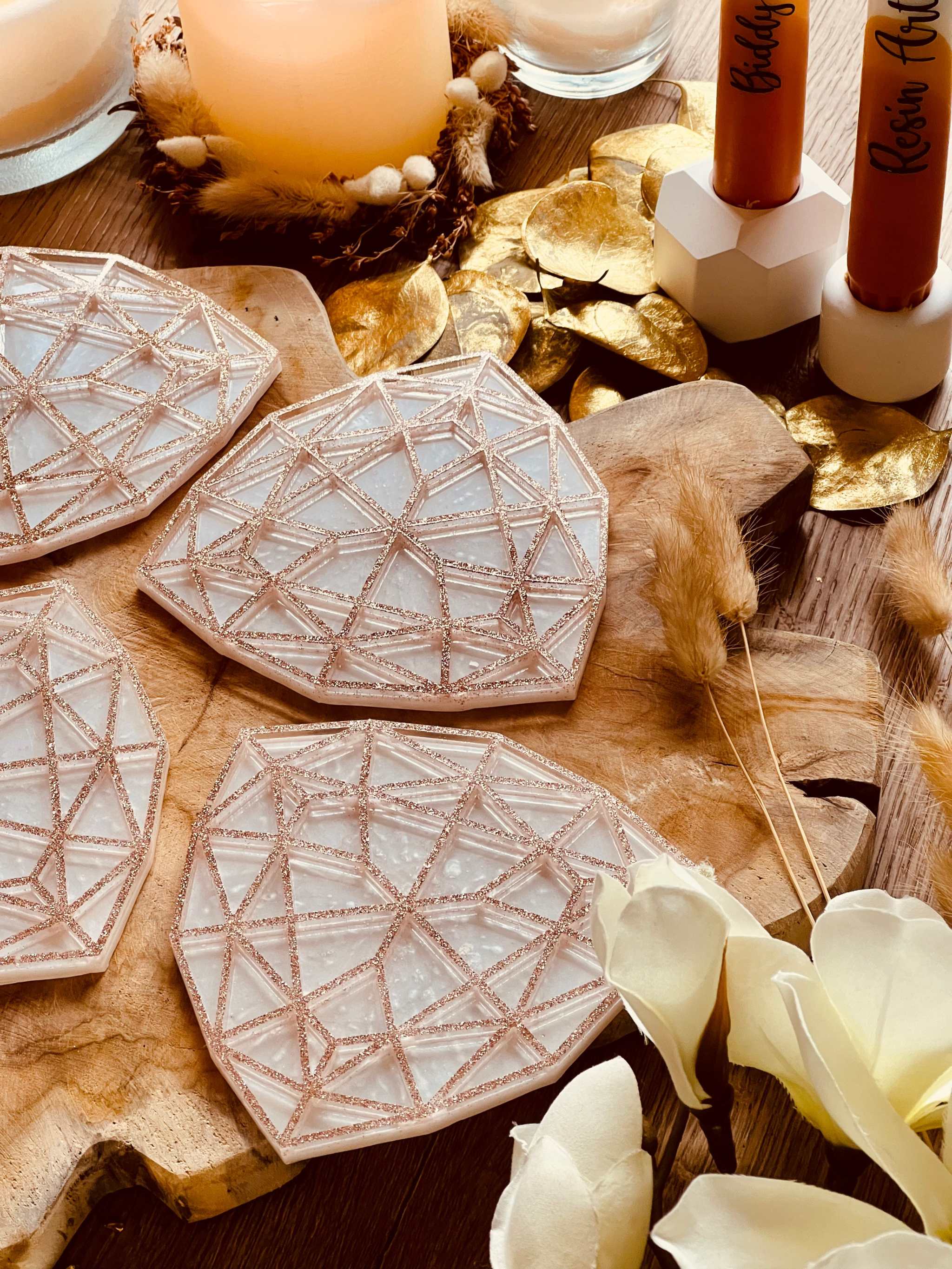 4 außergewöhnliche handgemachte Untersetzer aus weißem Resin mit goldfarbenem 3D-Design auf Holzplatte dekorativ arrangiert