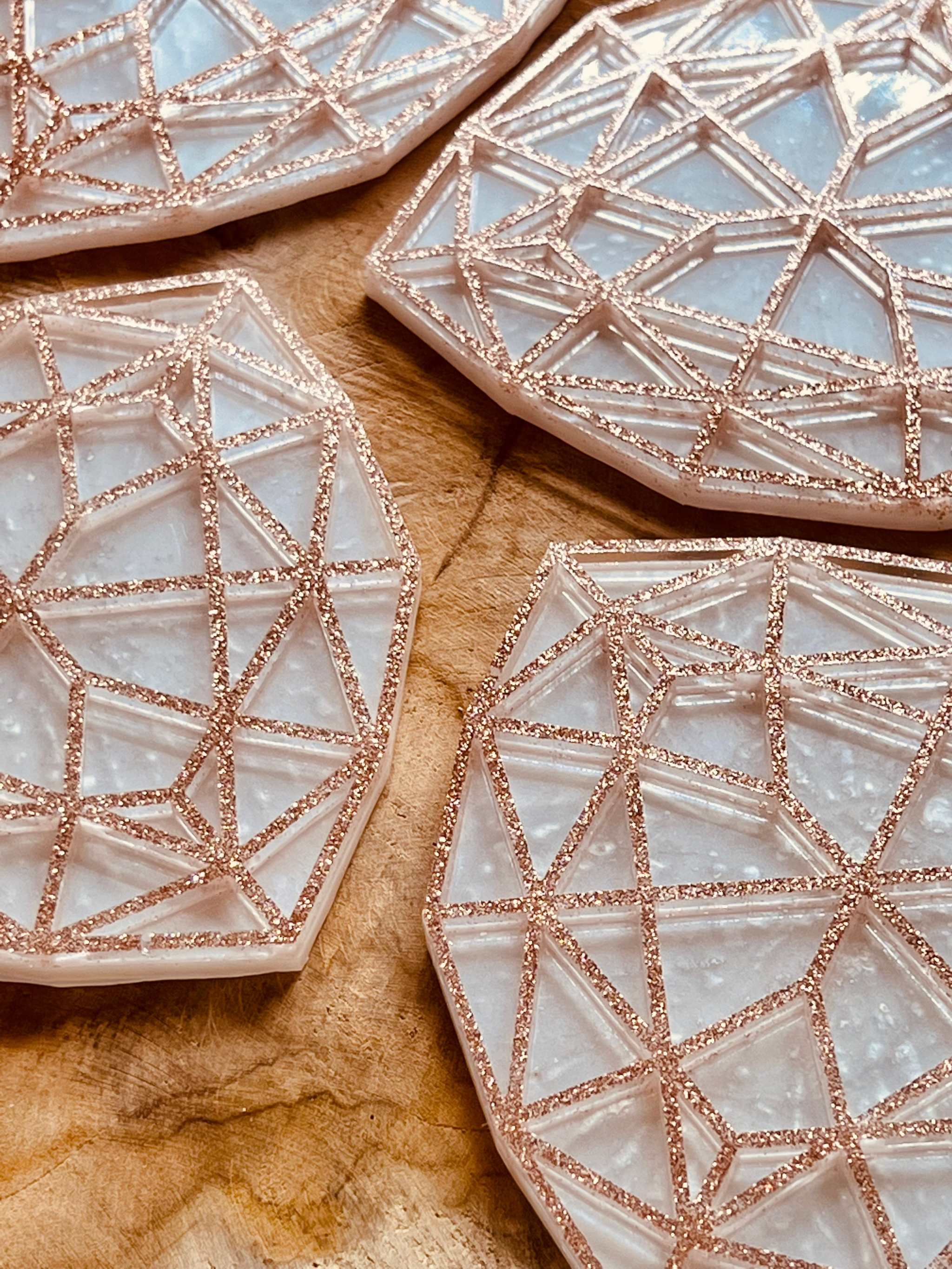4 außergewöhnliche handgemachte weiße Resin-Untersetzer mit goldenem 3D geometrischem Design auf Holztisch
