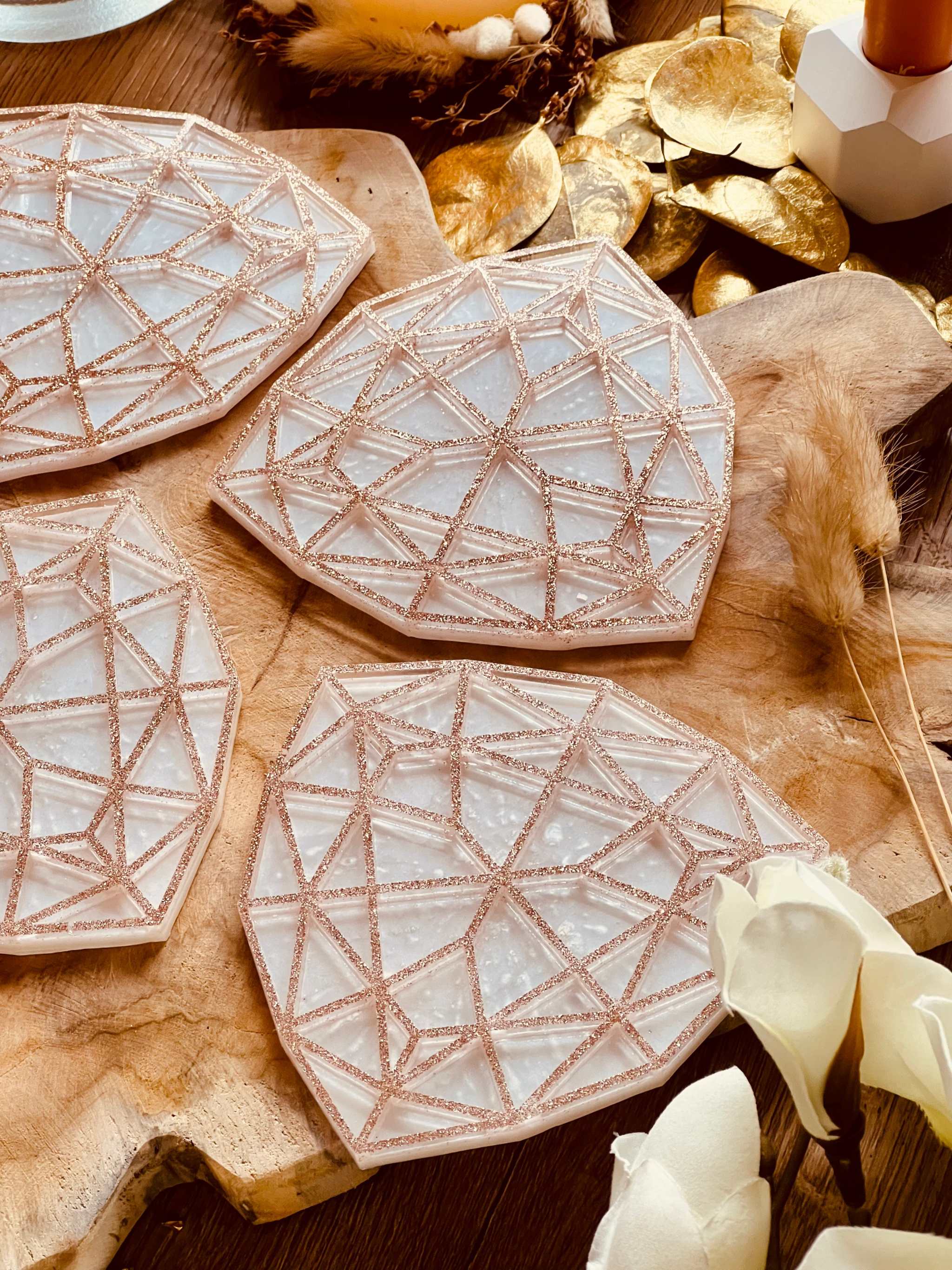 4 außergewöhnliche handgemachte weiße Resin-Untersetzer mit goldenem 3D-Geometrie-Design auf Holztisch