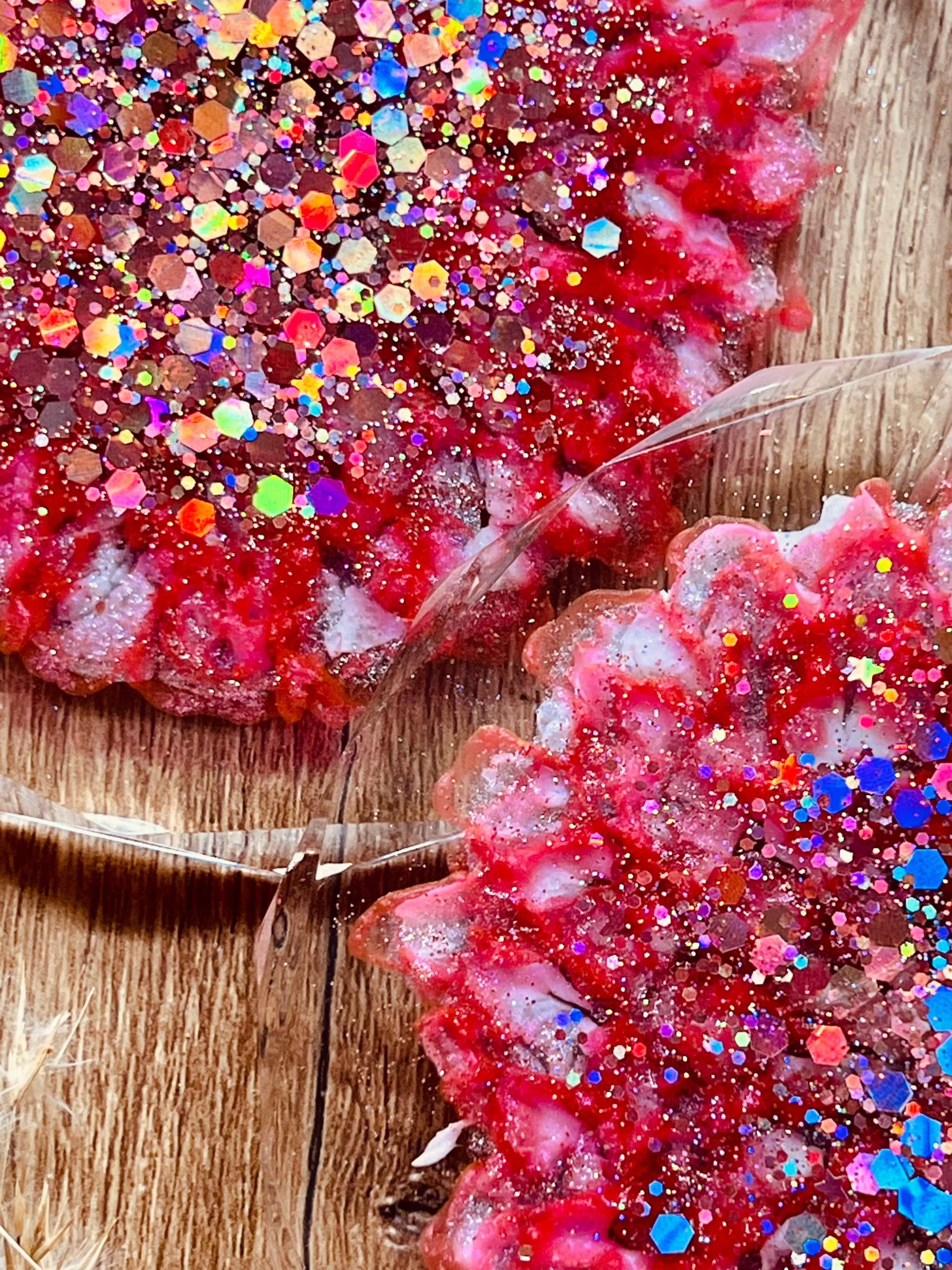 3 handgemachte Untersetzer aus Resin in Pink mit silbernen Glitzerdetails auf Holztisch