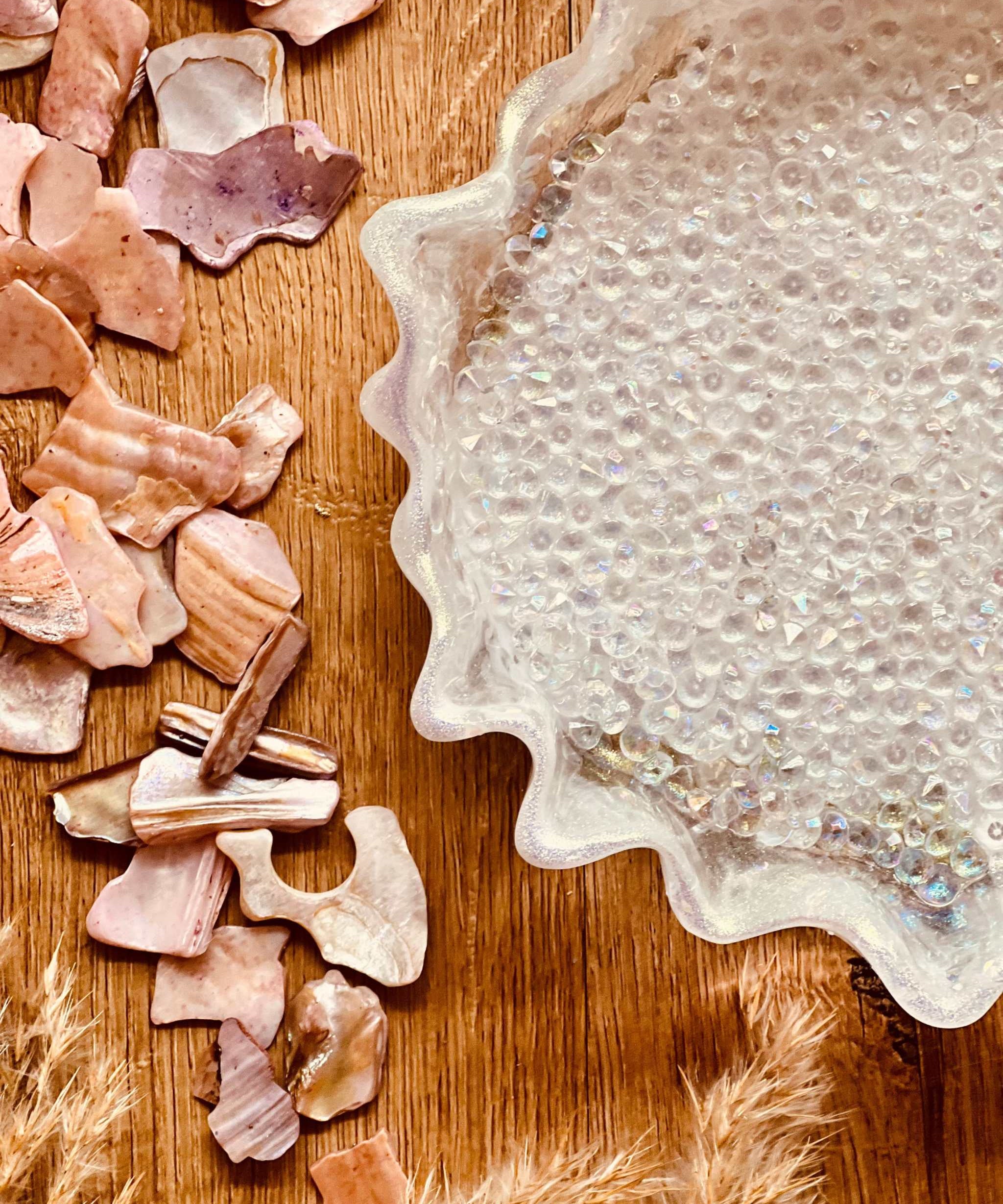 Handgemachte weiße Schale aus Resin mit Diamantlook und unregelmäßigem Rand auf Holztisch mit Dekosteinen