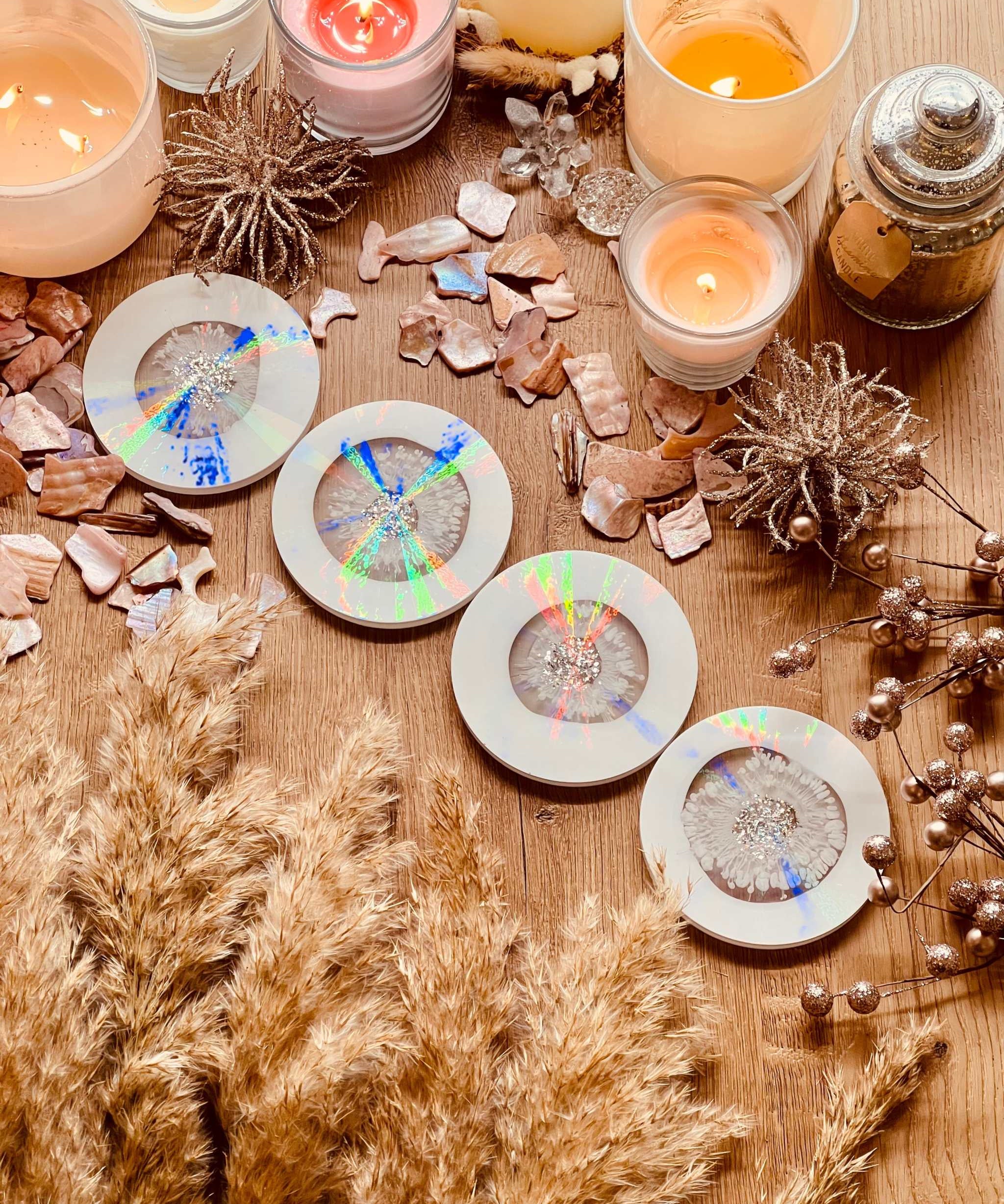 5 Untersetzer aus Resin in Weiss mit holographischem Design und silbernen Details auf Holztisch mit Kerzen und Dekoration