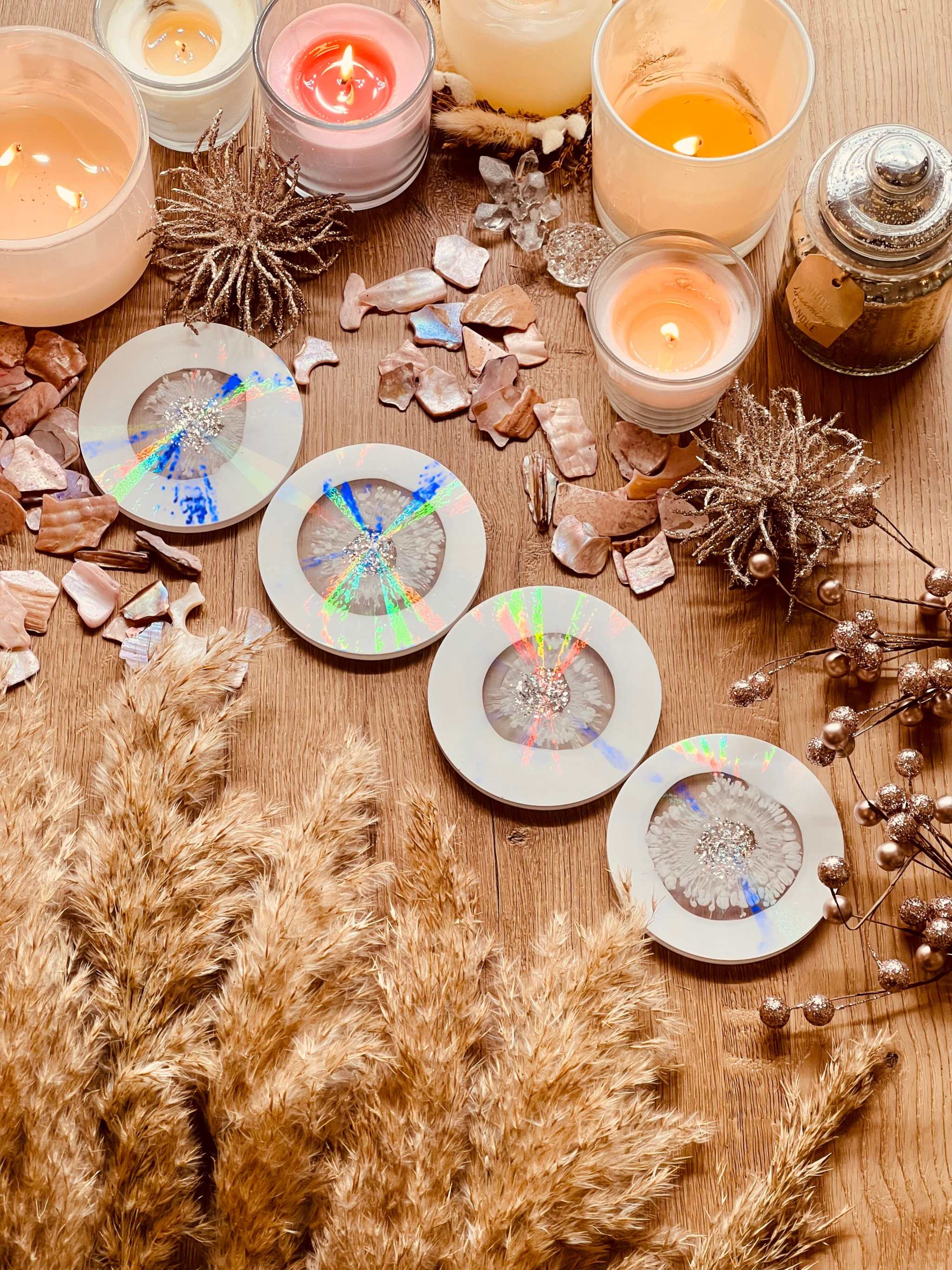 5 Untersetzer aus Resin in Weiss mit holographischem Design und silbernen Details auf Holztisch mit Kerzen und Dekoration