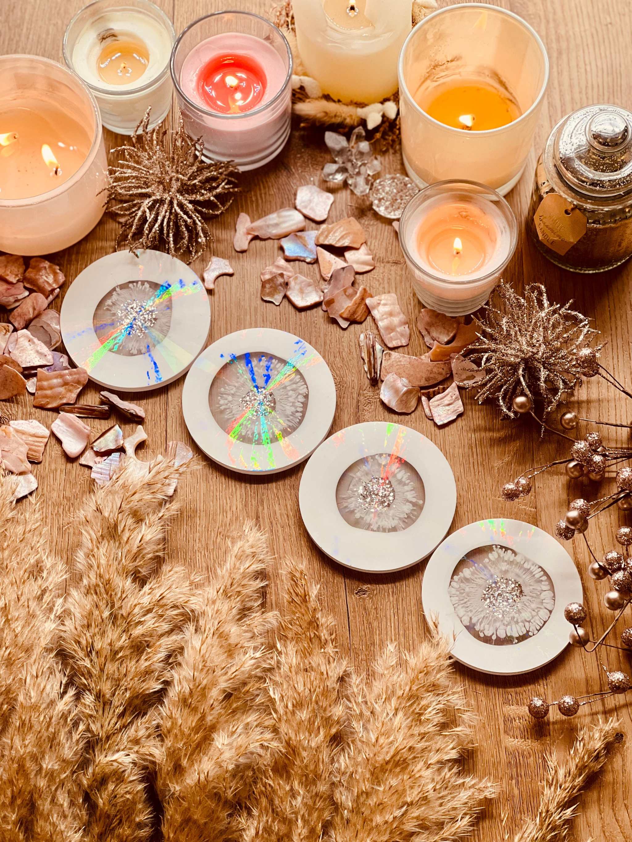 5 handgemachte weiße Untersetzer aus Resin mit silbernen Details und holographischem Design auf Holztisch mit Kerzen und Deko