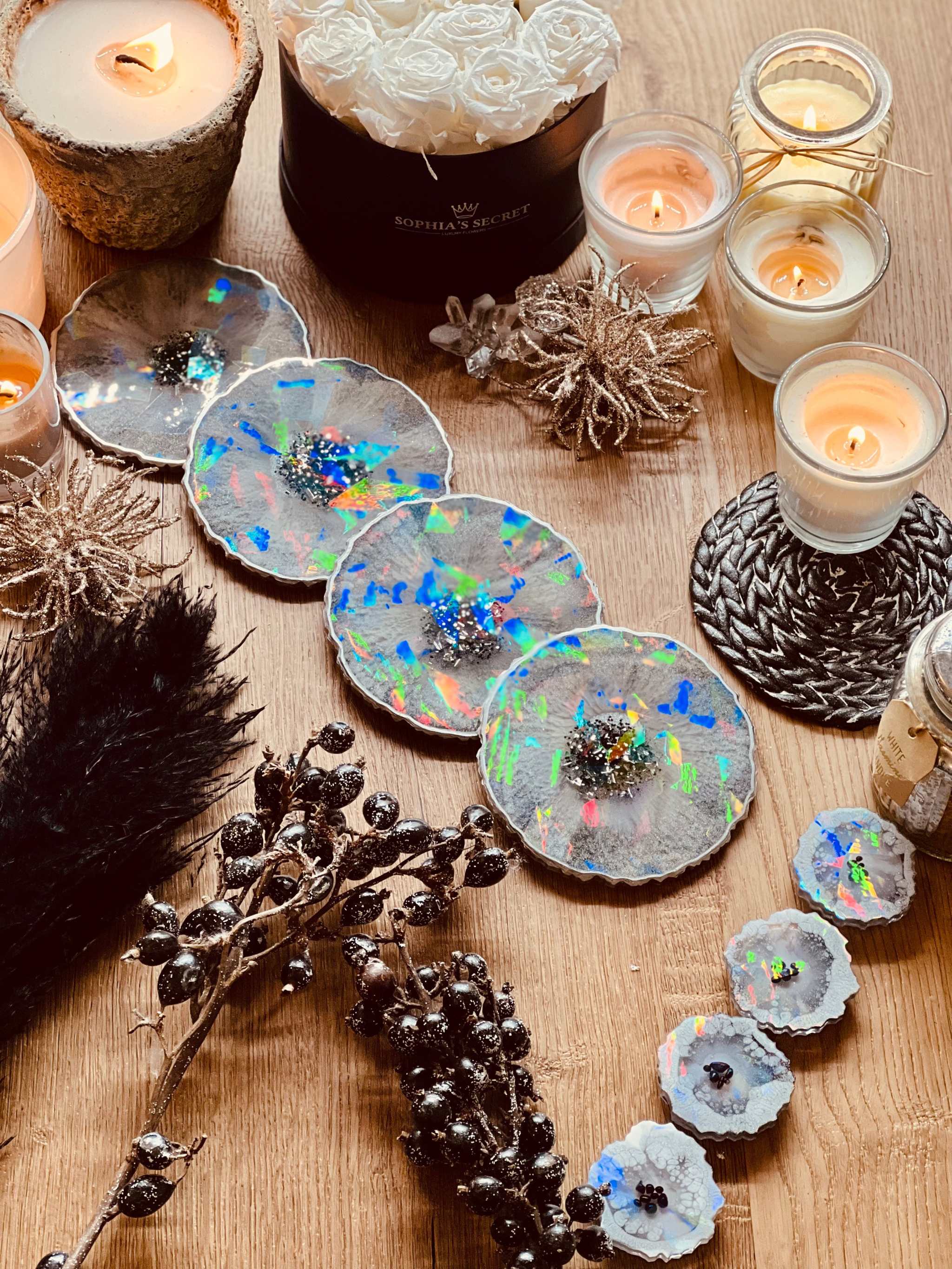 4 handgemachte holographische Untersetzer aus grauem Resin mit silbernen Details auf Holztisch mit Kerzen und Dekoration