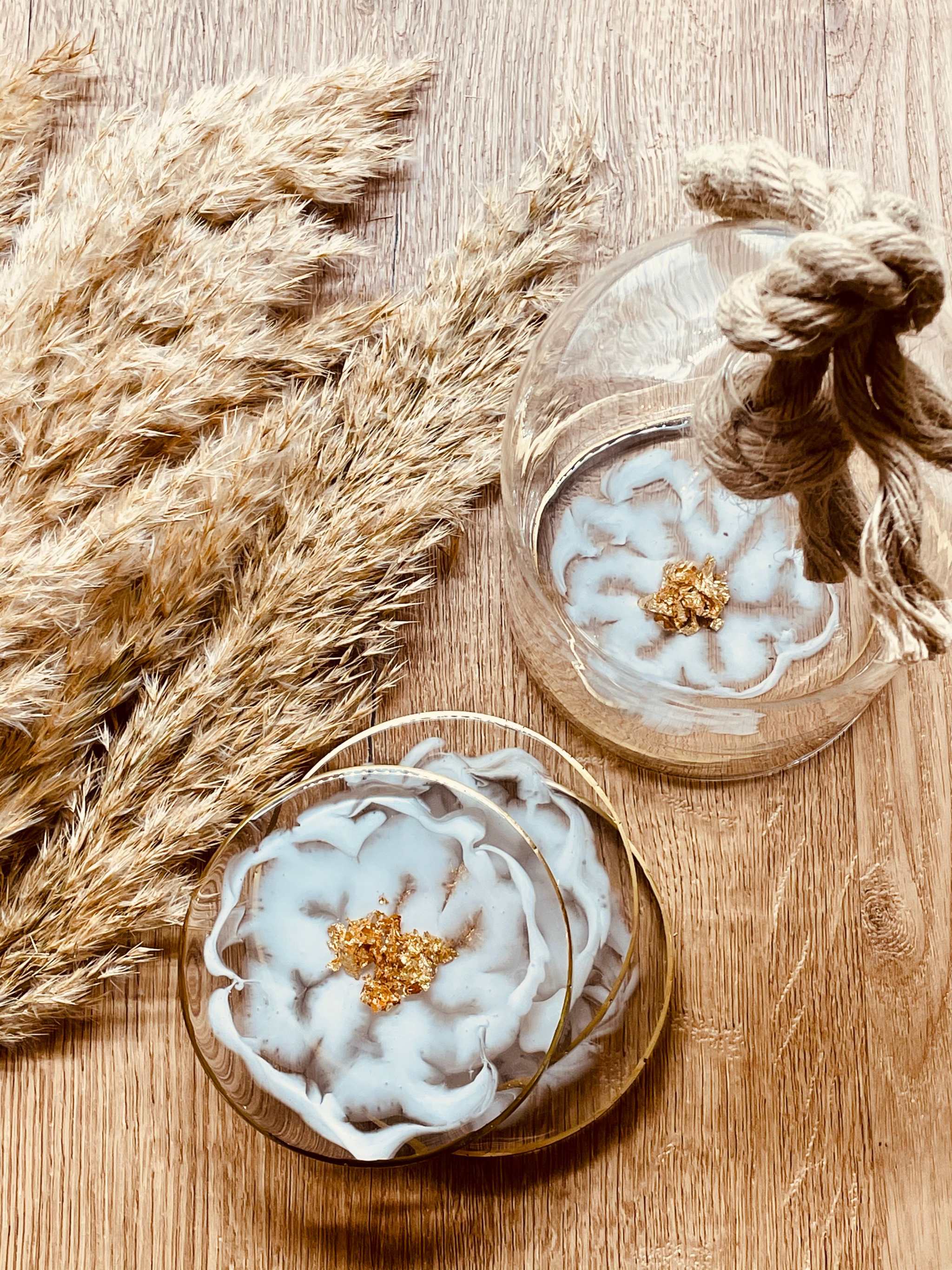 4 exklusive handgemachte weiße Resin Untersetzer mit goldenen Details im 4-teiligen Set auf Holztisch