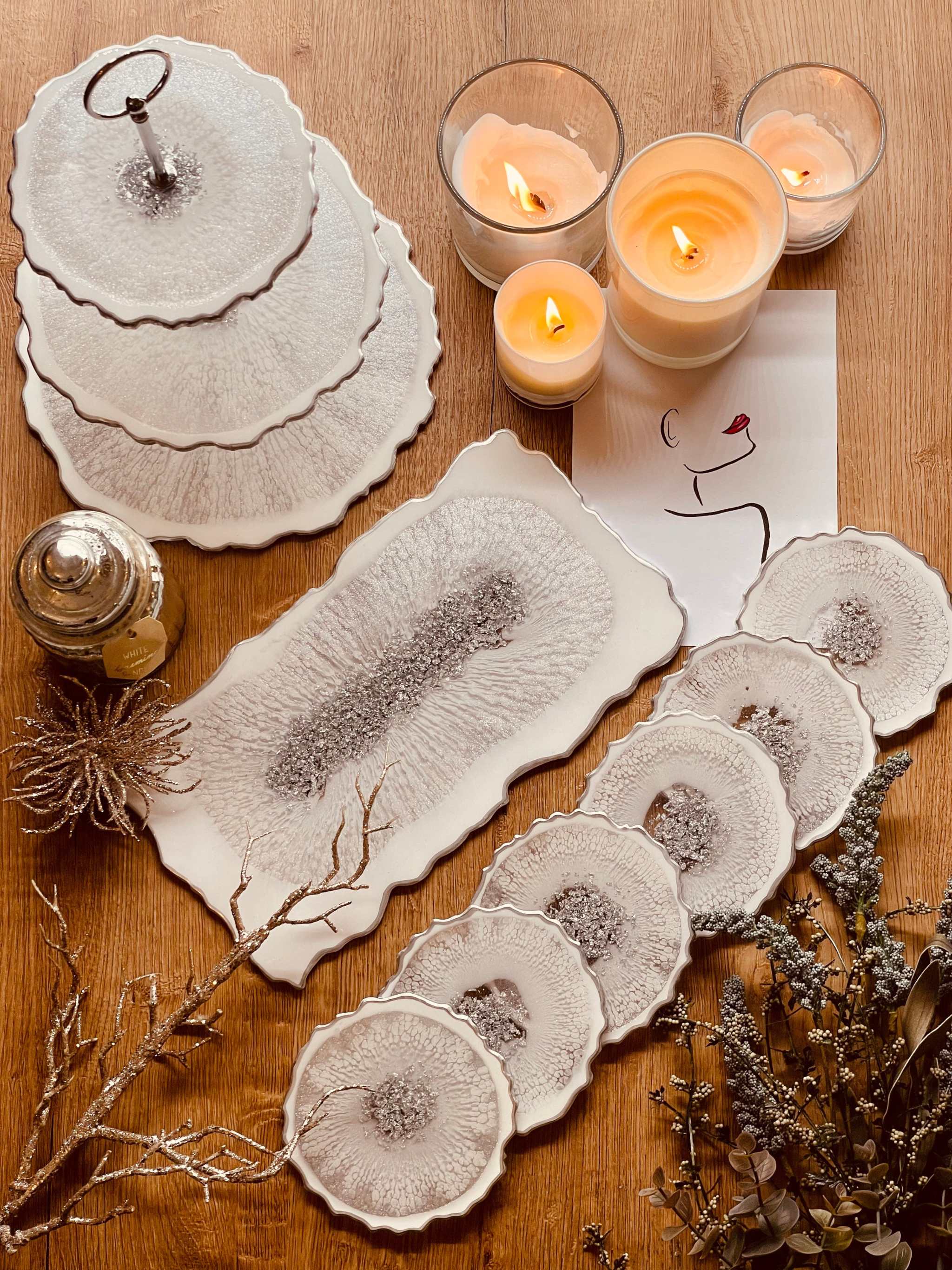 Handgemachte Deko Sets aus Resin mit unregelmäßigen Etagere, Schale, Untersetzern und Tablett in natürlichem Design auf Holztisch mit brennenden Kerzen