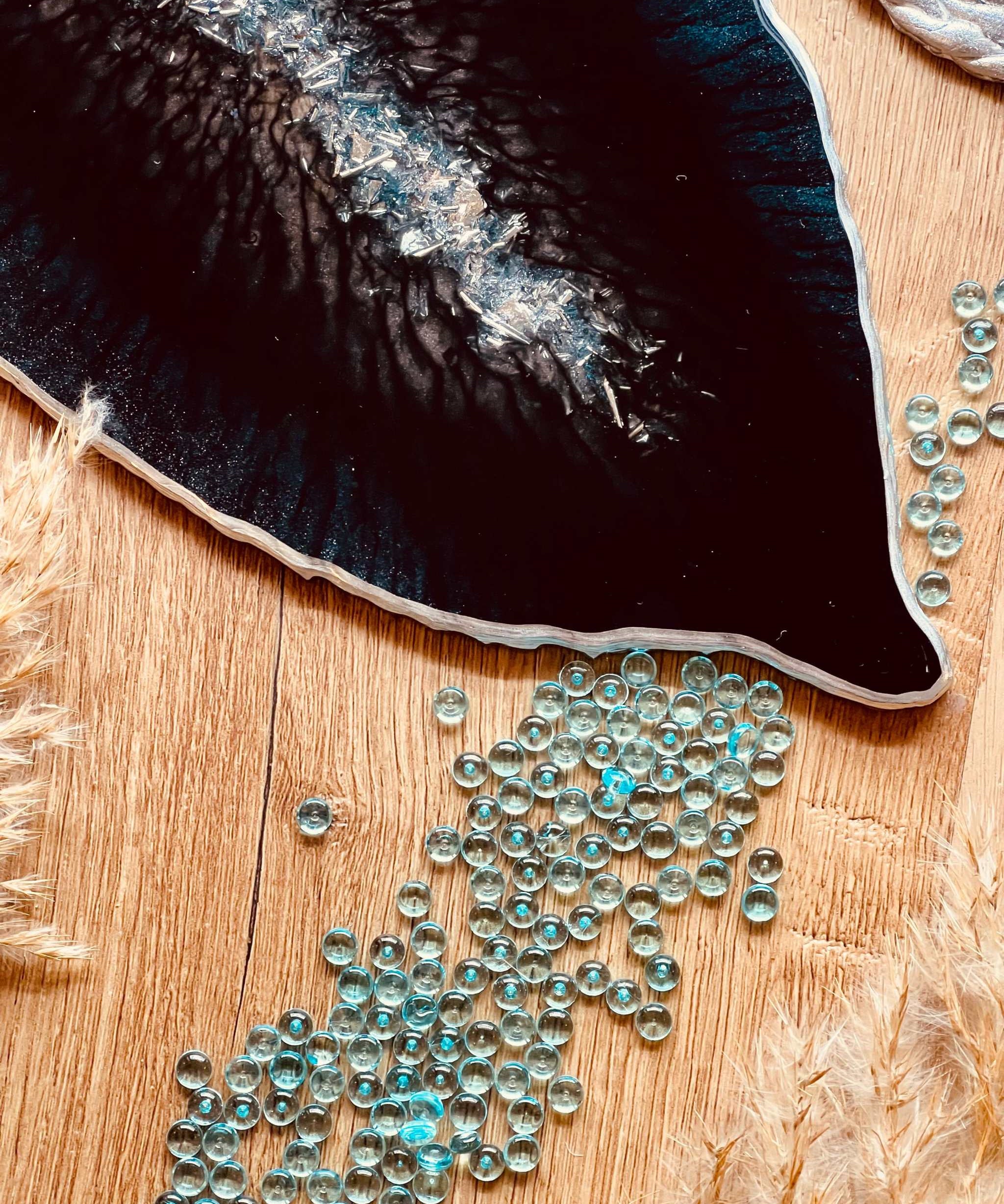 Handgemachtes schwarzes und petrolfarbenes Tablett aus Resin mit silbernen Details auf Holztisch
