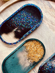 Schmuckschalen aus Resin in grün mit goldenen Details und holographisch schwarz als handgemachte Unikate auf Holzplatte