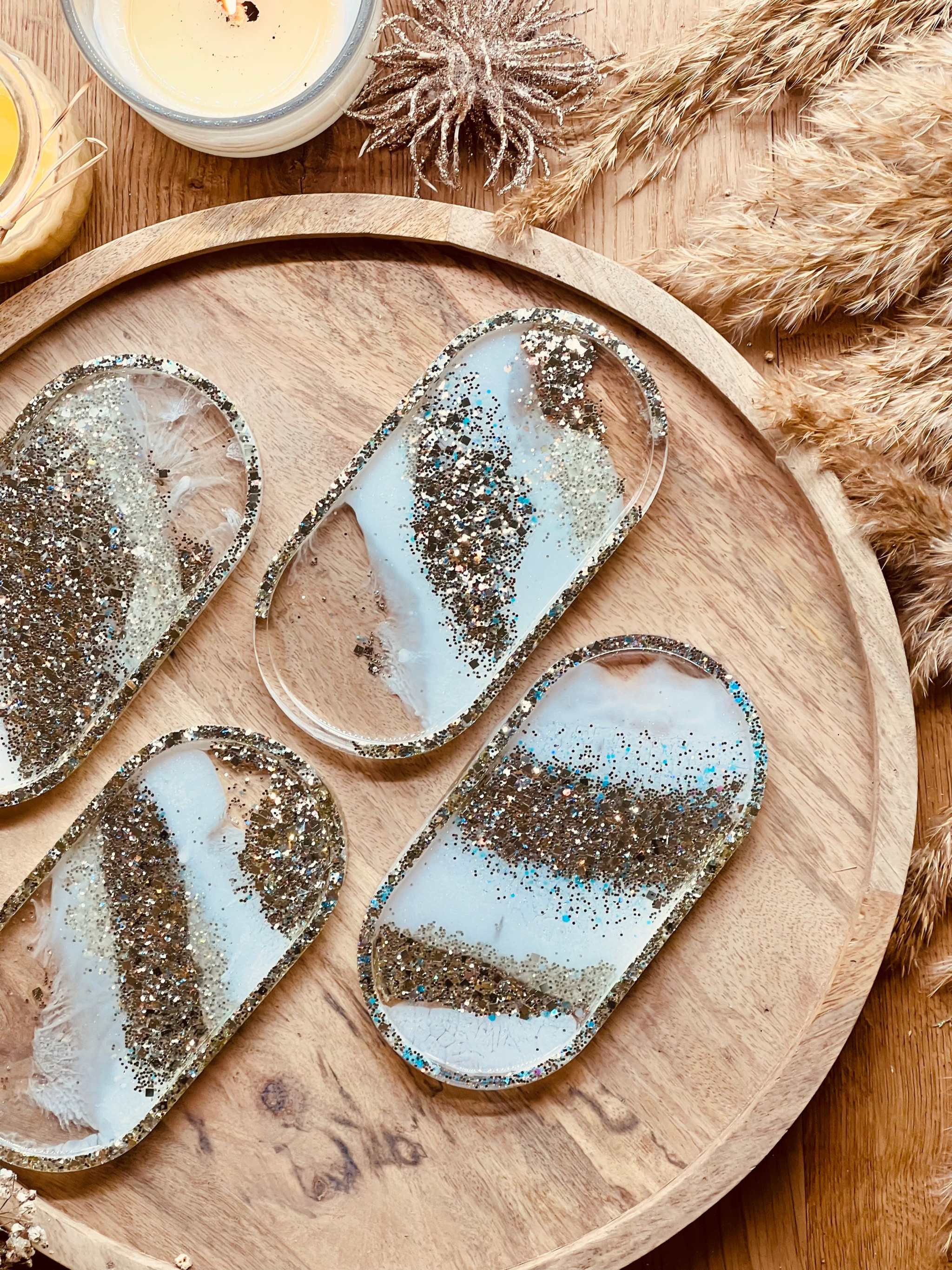 Handgemachte weiße Schmuckschalen aus Resin mit champagnerfarbenen Details auf Holztablett