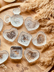 Handgemachte weiße Schmuckschalen aus Resin mit silbernen Details in verschiedenen Formen auf Holzplatte