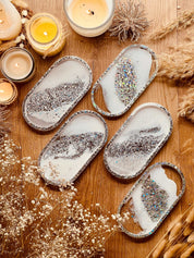 handgemachte weiße schmuckschalen aus resin mit silbernen details auf holztisch dekoriert
