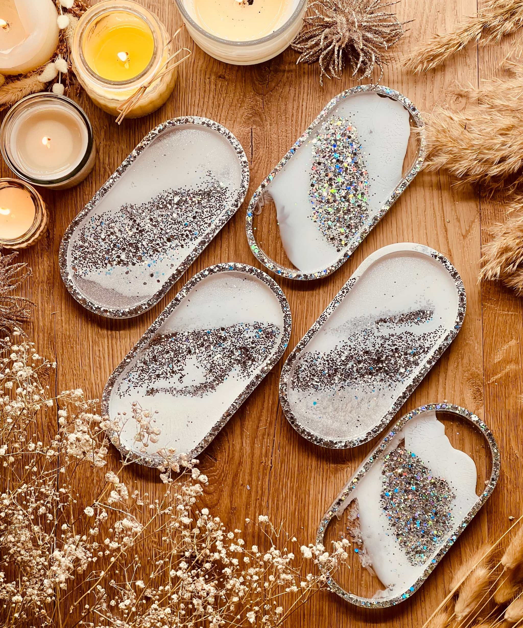 handgemachte weiße schmuckschalen aus resin mit silbernen details auf holztisch dekoriert