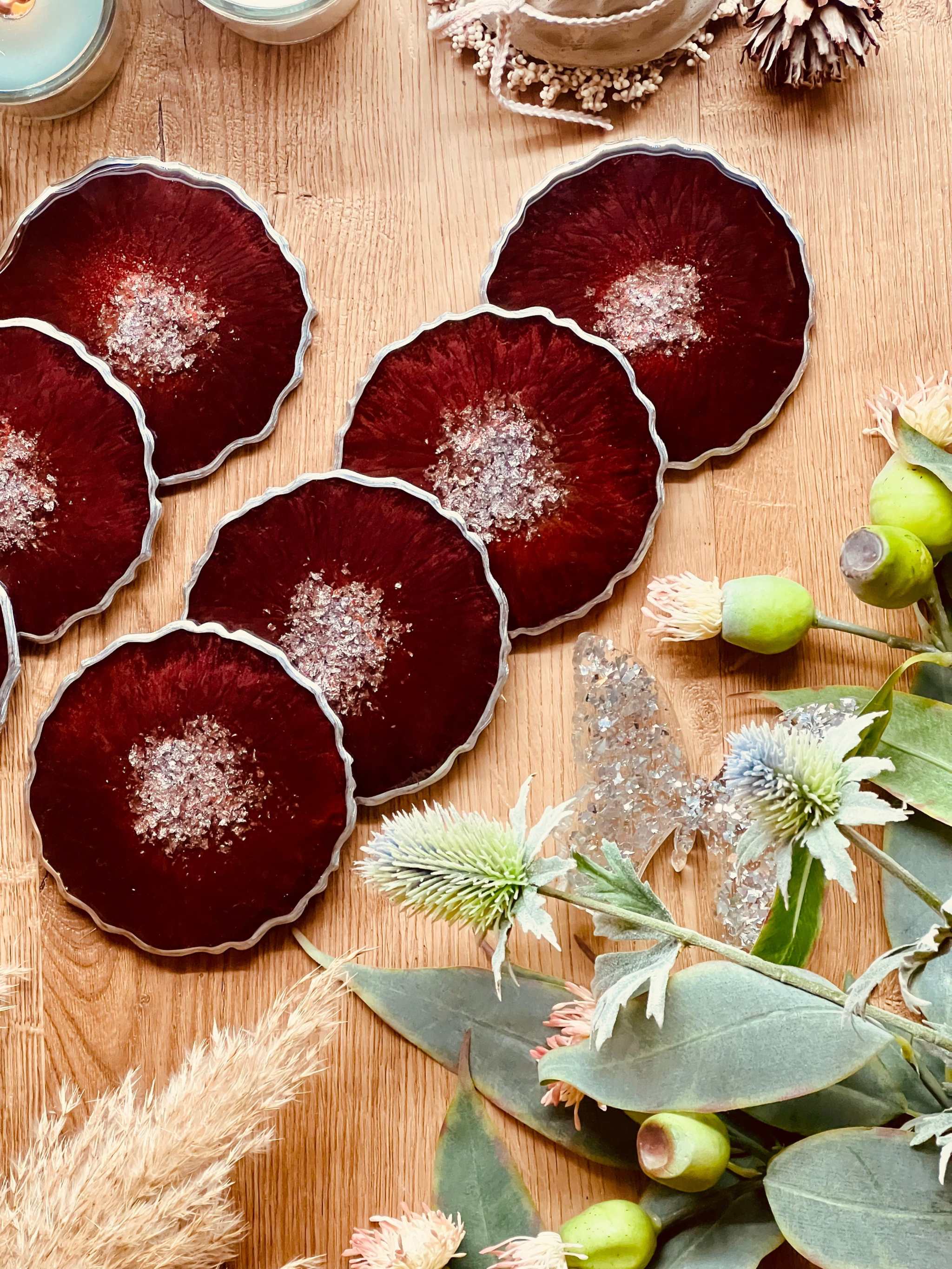Handgemachte rote Untersetzer aus Resin in einzigartigem Design auf Holztisch mit Dekoration