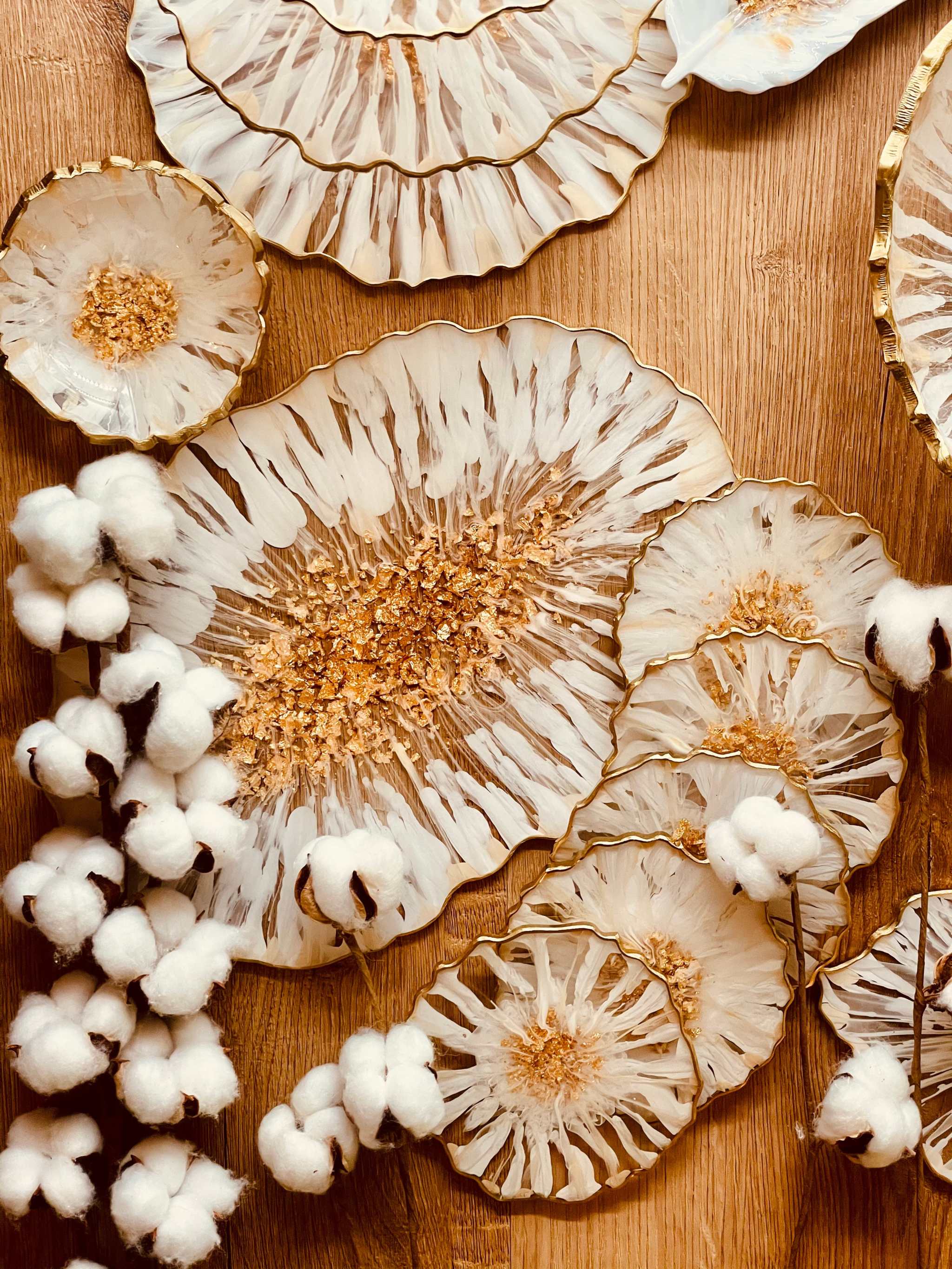 weiß-goldenes handgefertigtes Deko Set aus Epoxidharz mit 3D-Streifenmuster, Schalen, Tabletts und Untersetzern auf Holztisch