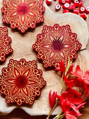 Handgemachte winterliche Untersetzer aus Resin in Rot mit goldenen Verzierungen, 4-teiliges Set auf Holzplatte
