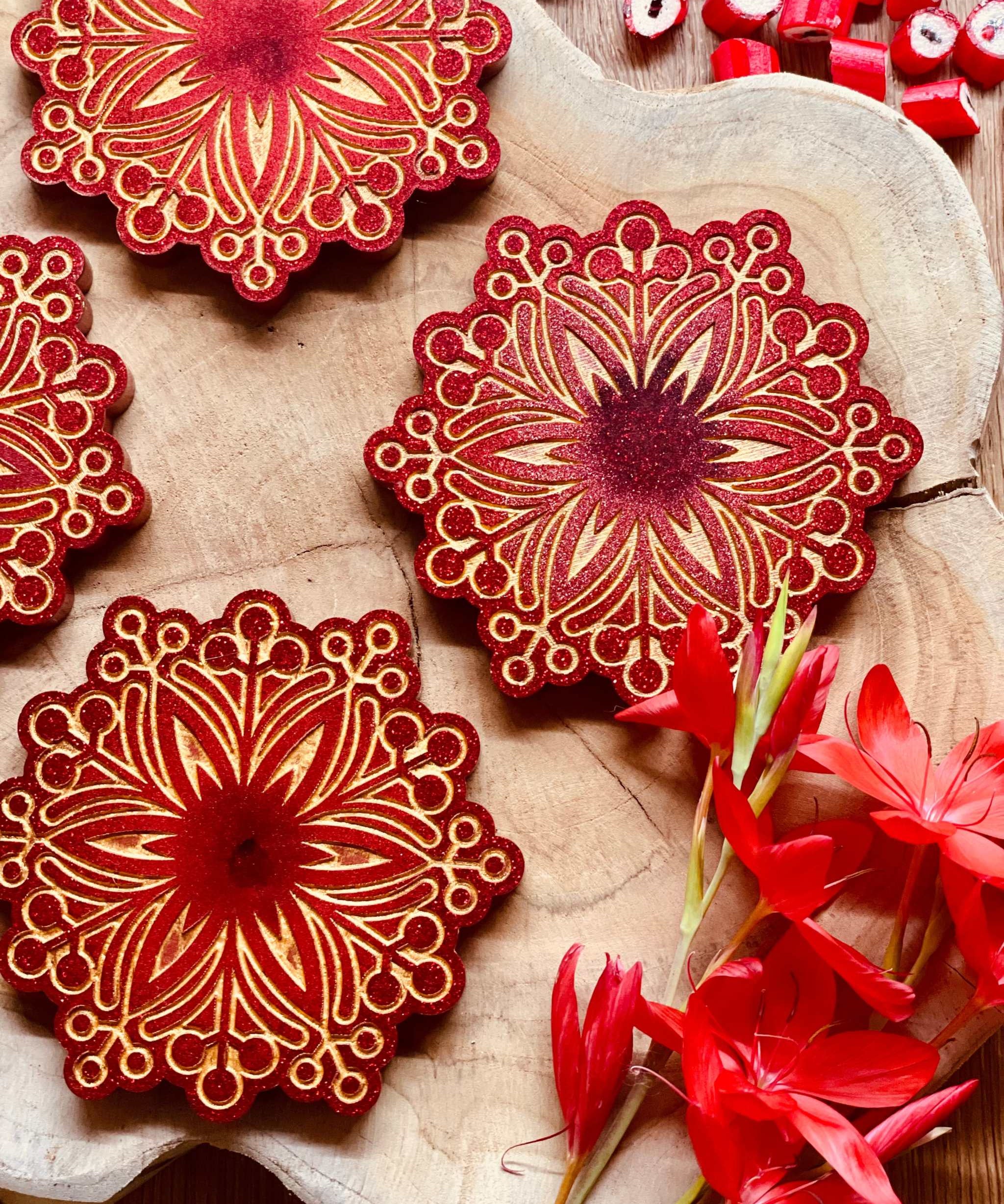 Handgemachte winterliche Untersetzer aus Resin in Rot mit goldenen Verzierungen, 4-teiliges Set auf Holzplatte