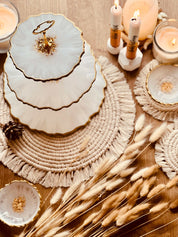 Dreistöckige handgemachte Resin-Etagere mit goldenen Akzenten auf natürlichem Tischset und Kerzenarrangement