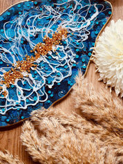 Handgemachtes blaues Resin Tablett mit goldenen Details und weißem Muster auf Holz mit dekorativen Pflanzen