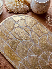 Handgemachtes Tablett aus Resin in Gold mit Weiß und Glitzer als dekoratives Unikat auf Holztisch