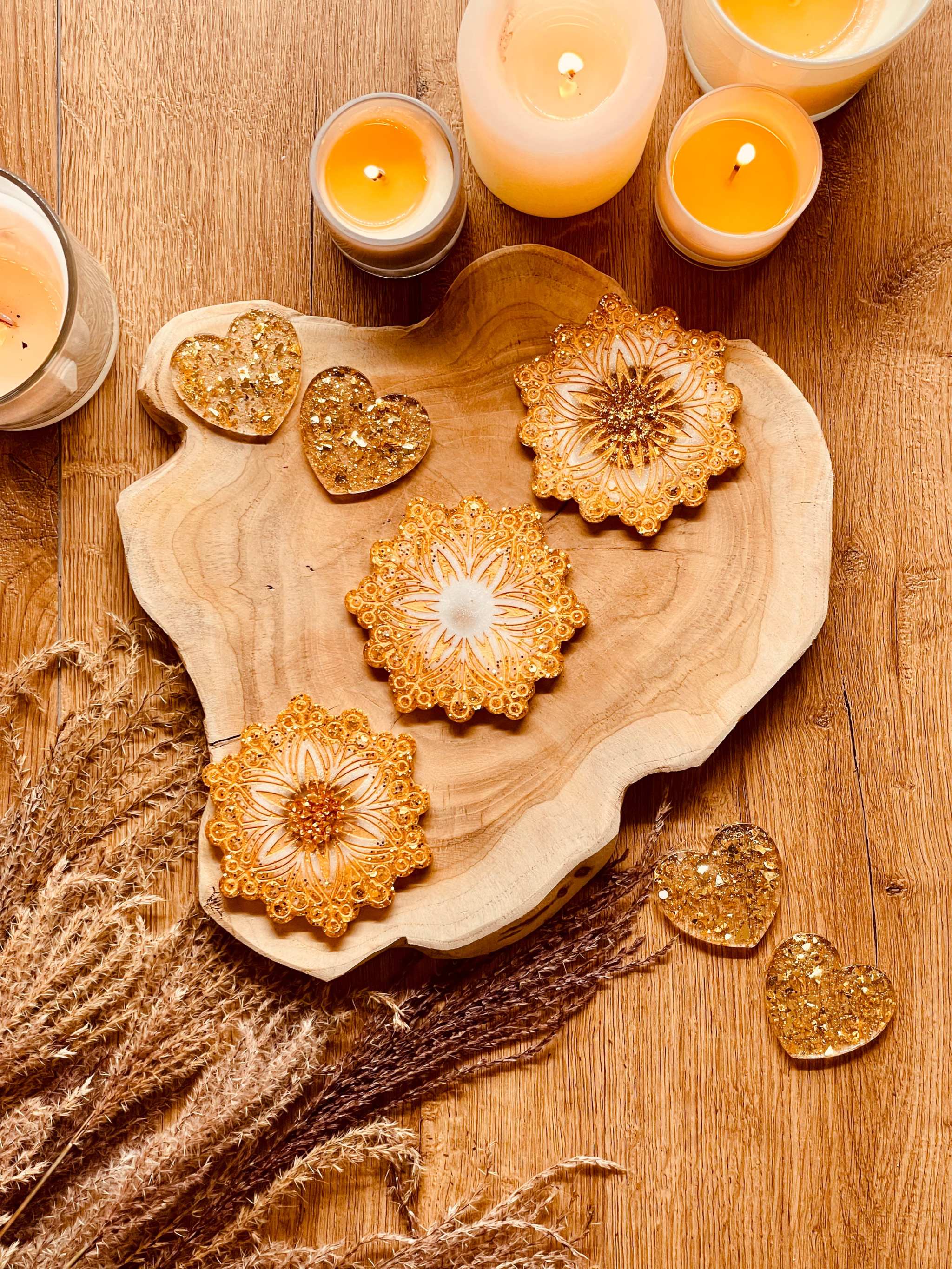 Three gold and white resin coasters on wooden table for Weihnachtliche Deko.