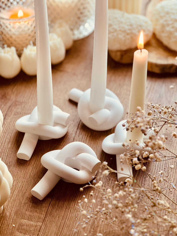 Modern candle holder made of cast ceramic in knot design 
