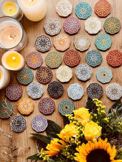 bunte handgemachte Mandala Untersetzer aus Resin mit Kerzen und Sonnenblumen auf Holztisch