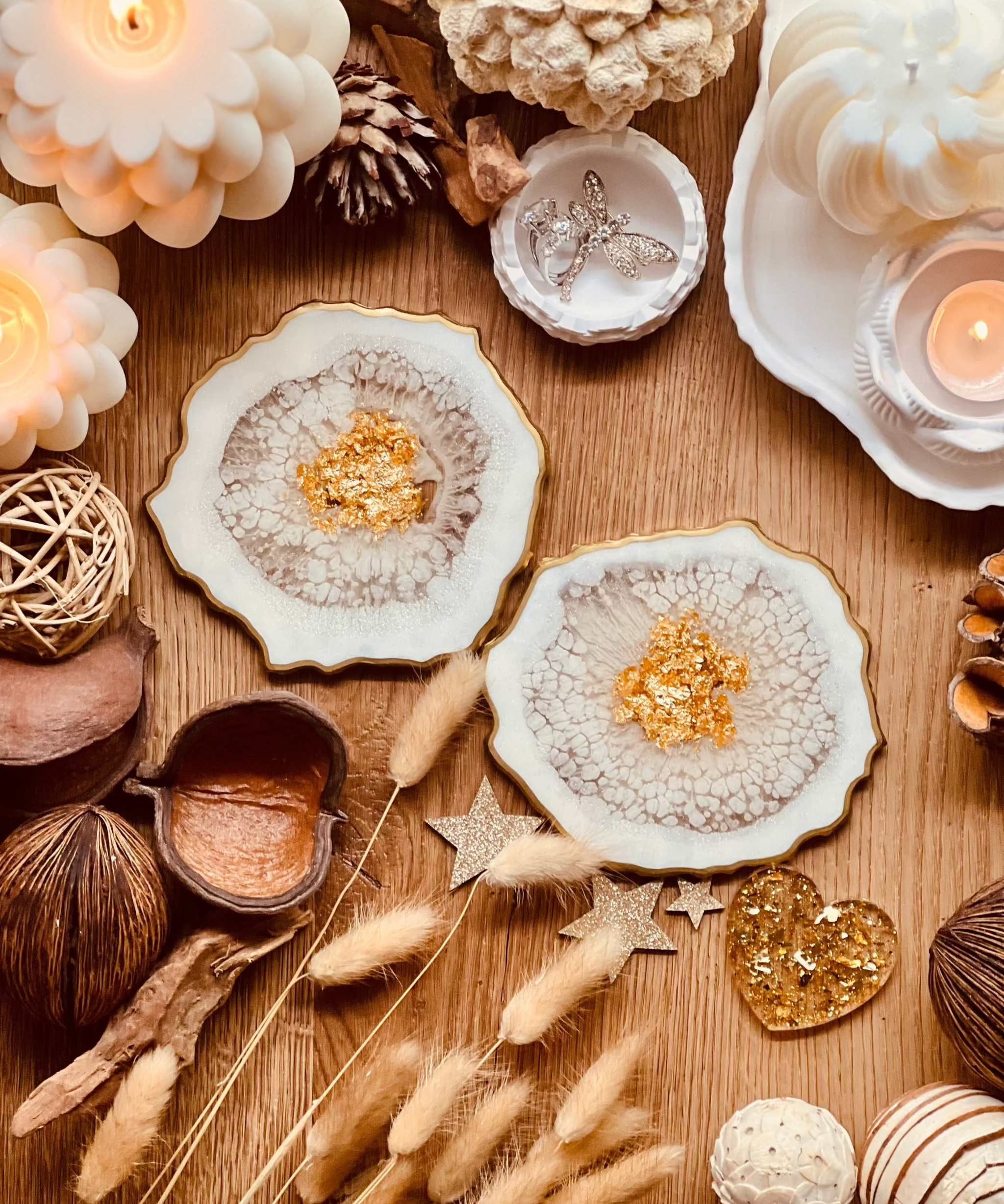 Weisse detailreiche Untersetzer aus Resin mit goldenen Akzenten im 2er Set auf Holztisch dekoriert