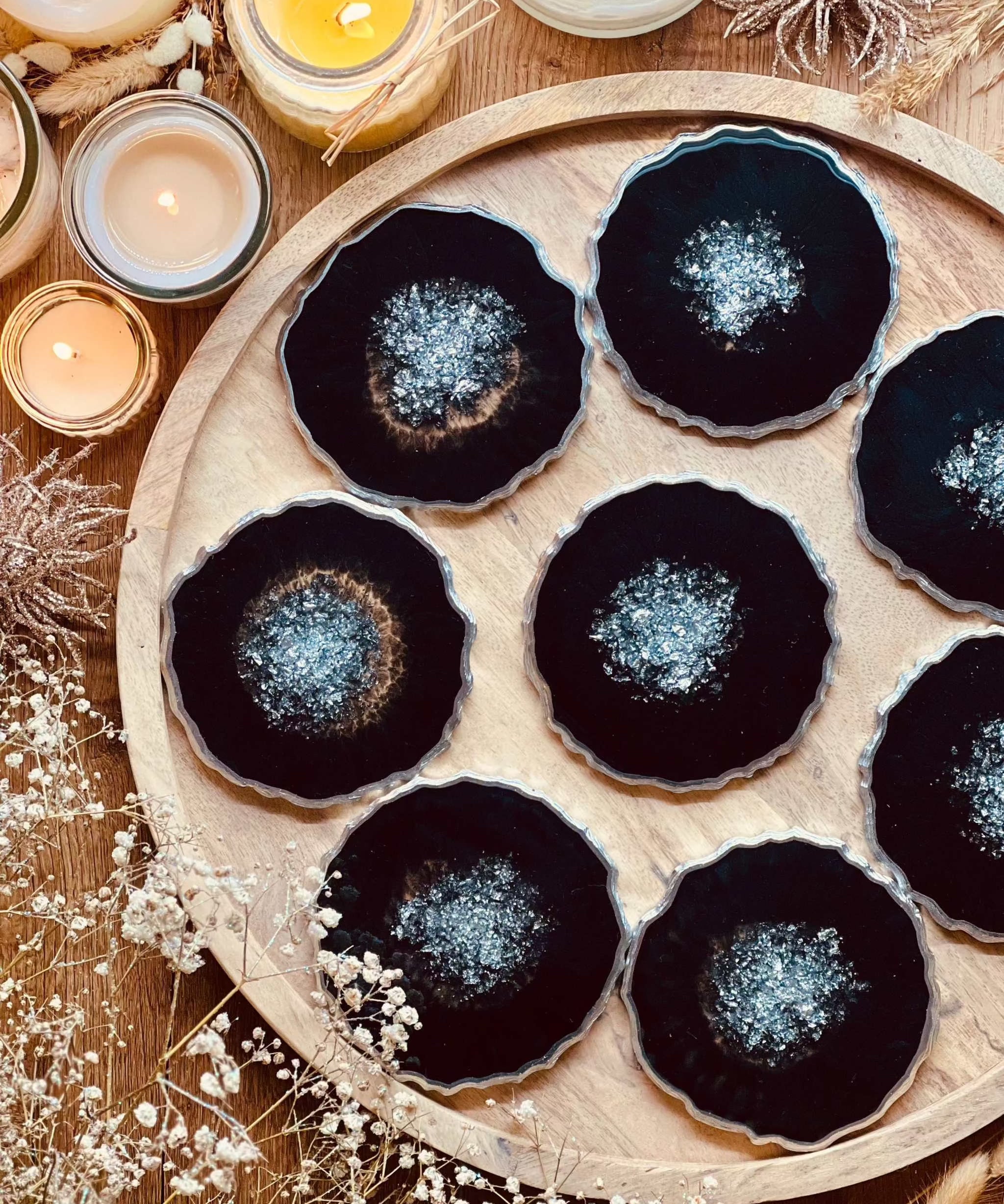 8 schwarze Resin Untersetzer mit silbernen Details handgemacht auf Holztablett
