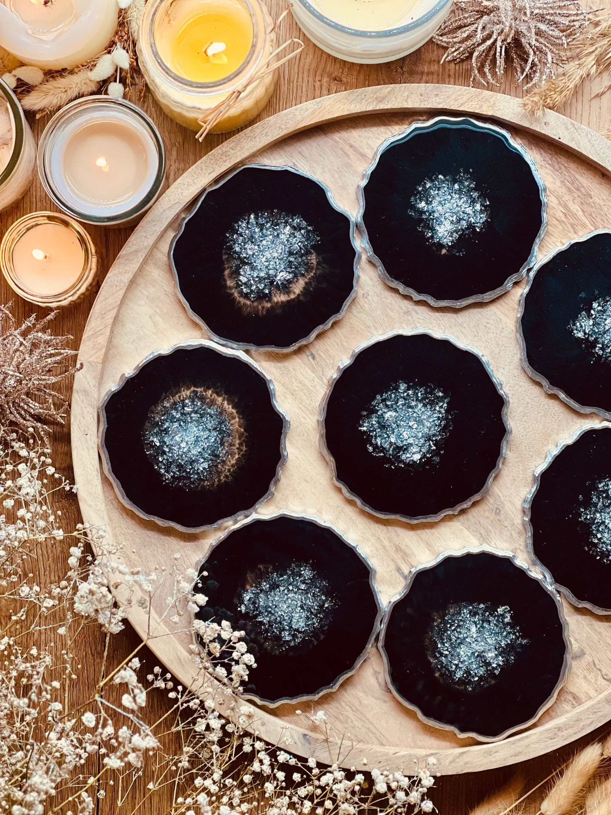 8 schwarze Resin Untersetzer mit silbernen Details handgemacht auf Holztablett