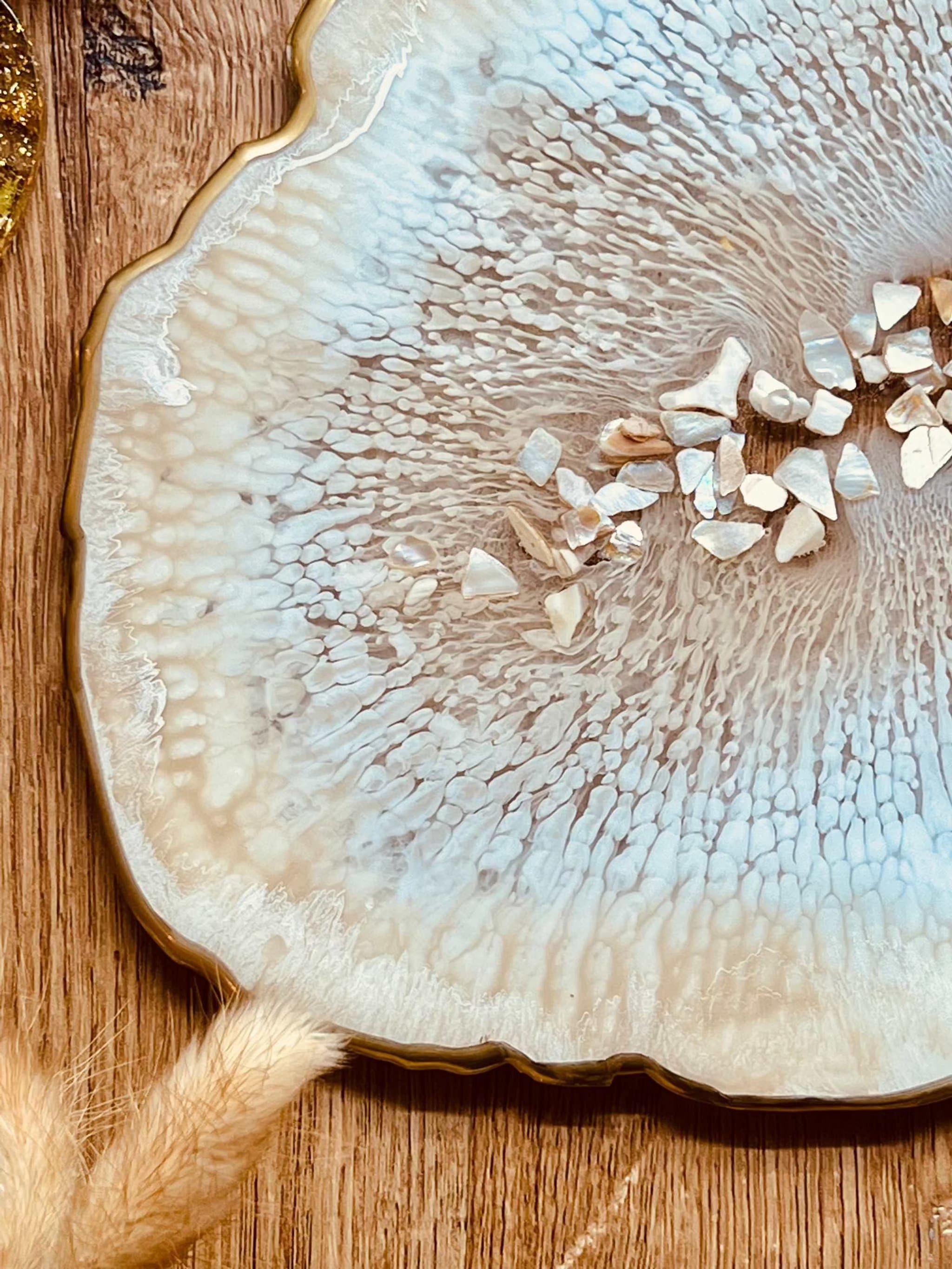Beiges handgemachtes Tablett aus Resin mit goldenen Details und Perlmutt auf Holztisch